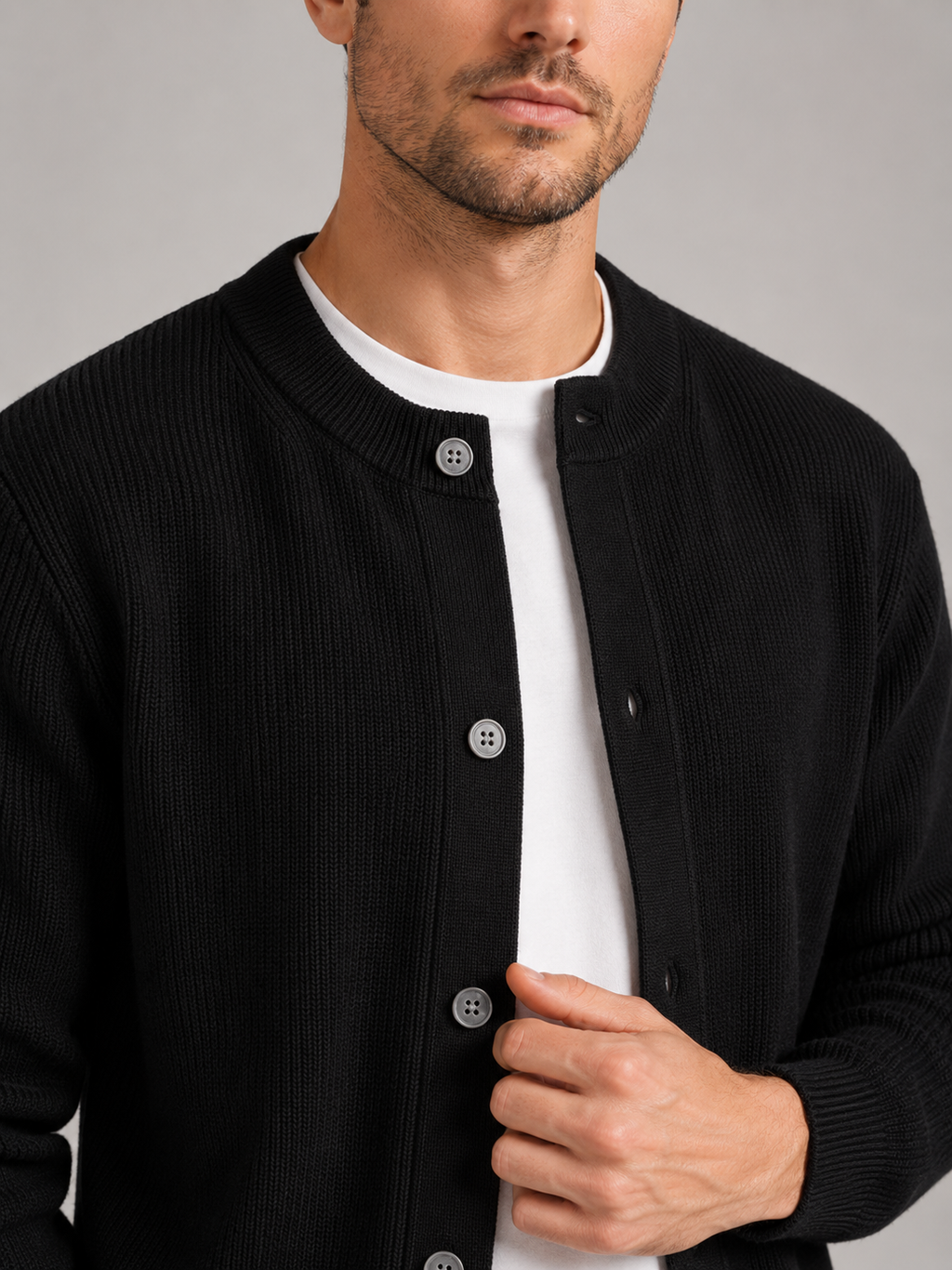 Close up of black knit cardigan showing soft textured fabric and classic crew neck detail