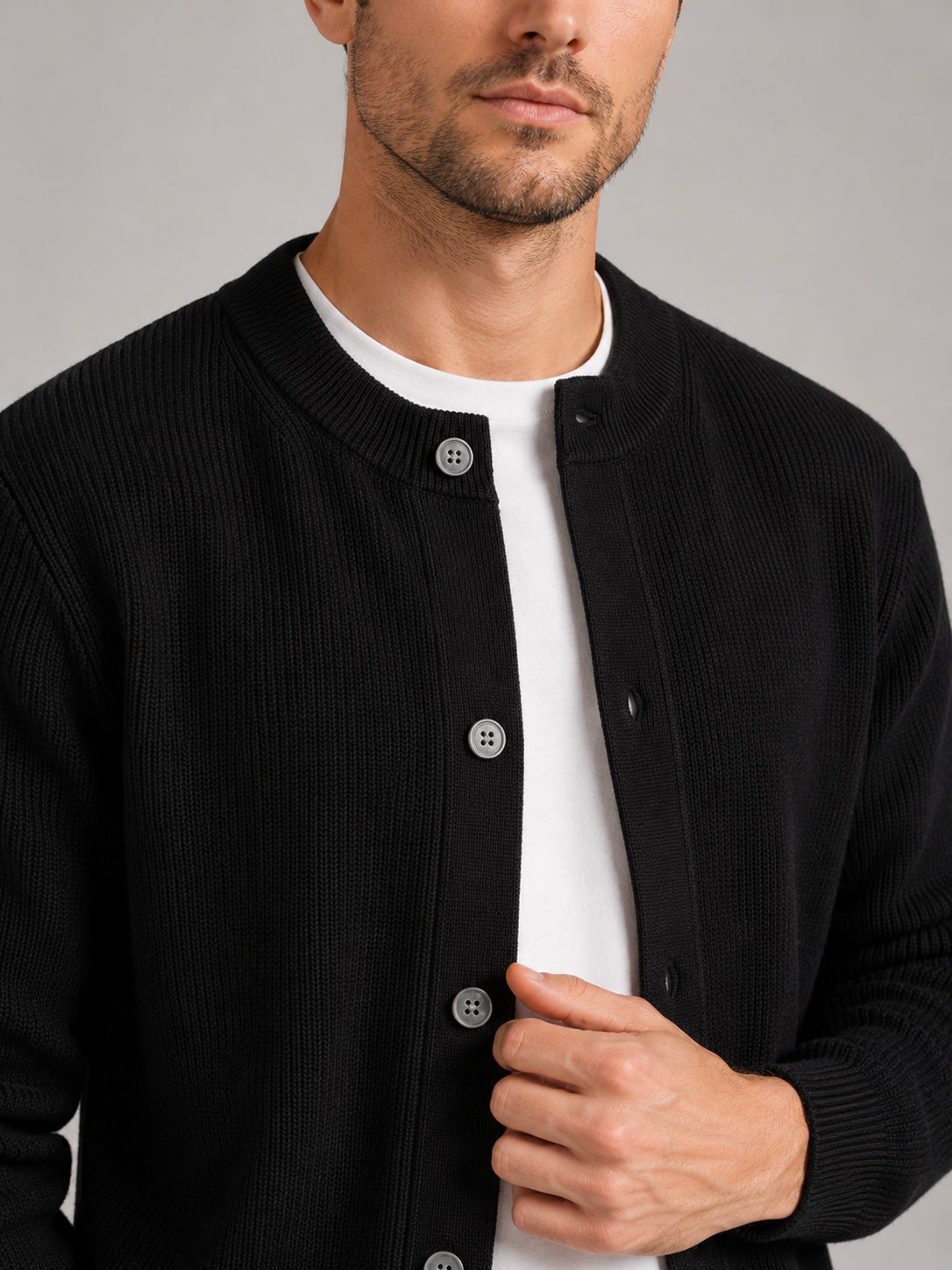 Close up of black knit cardigan showing soft textured fabric and classic crew neck detail