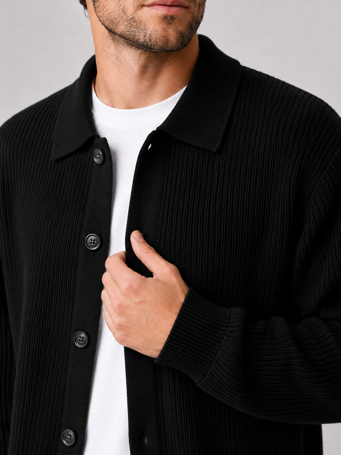Close up of black knit cardigan showing soft textured fabric and relaxed lapel collar detail