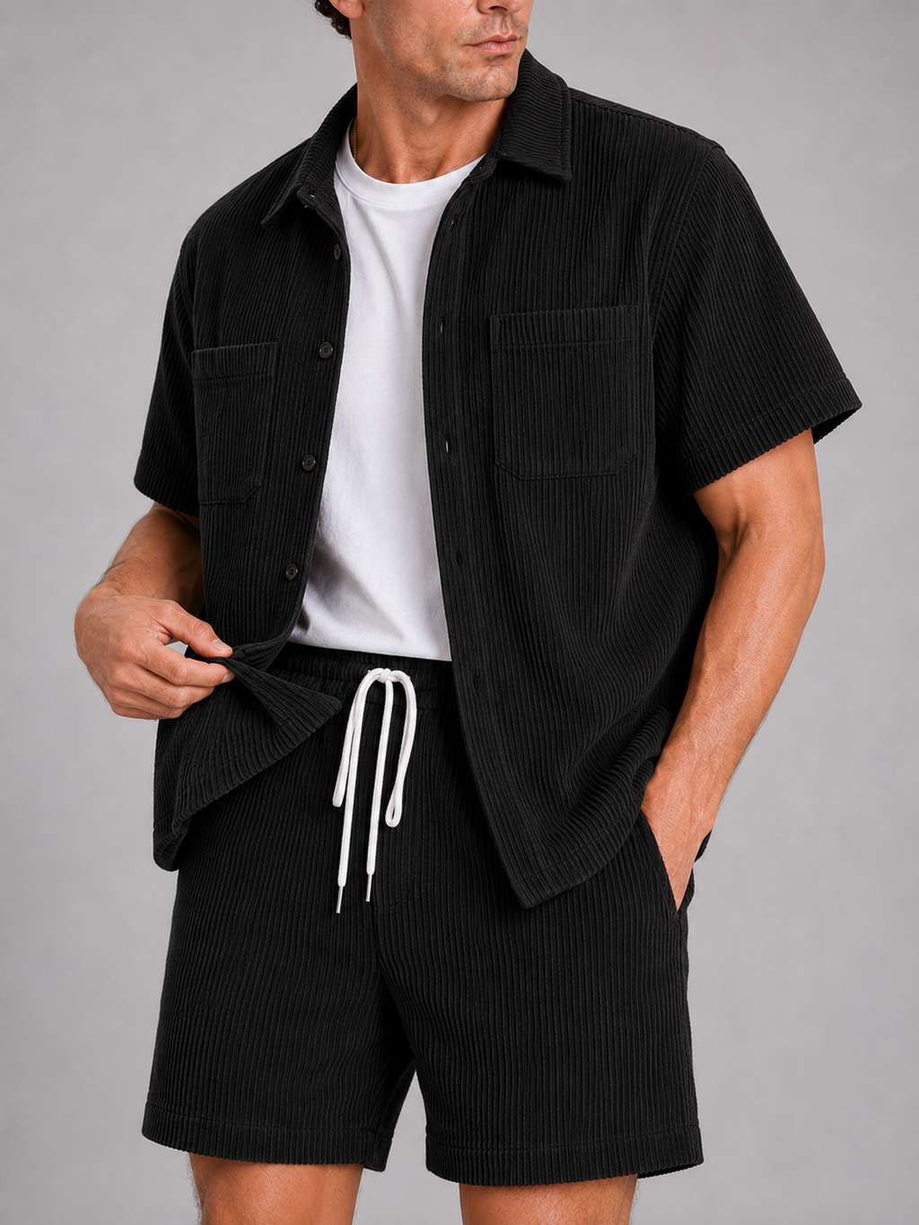 Close up of black corduroy two piece set showing soft textured fabric and button up shirt detail