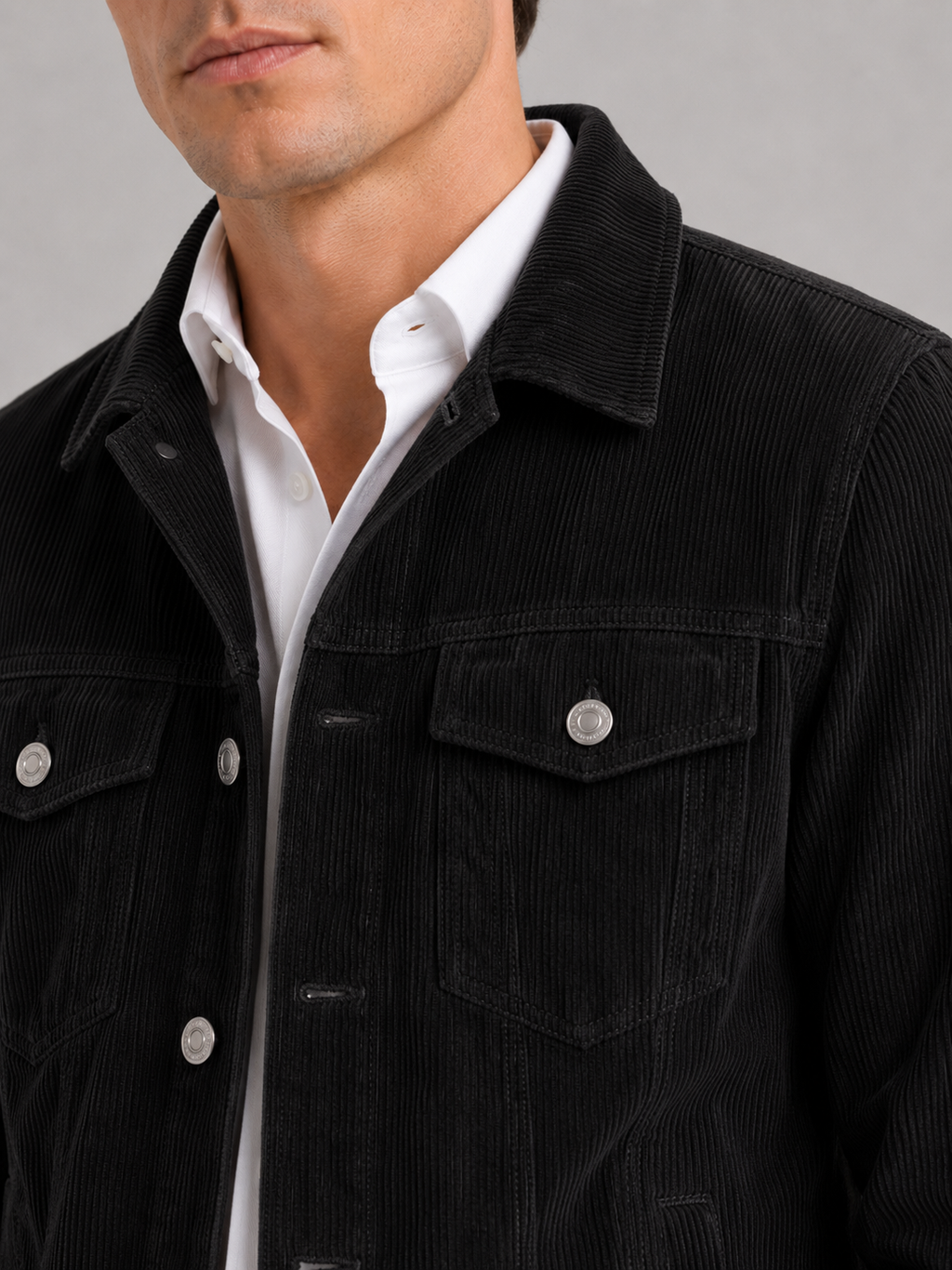 Close up of black corduroy jacket showing soft ribbed texture and refined fabric detail