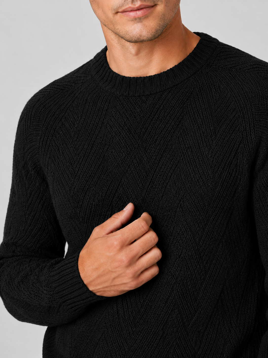 Close up of black knit sweater showing soft textured fabric and classic crew neck detail