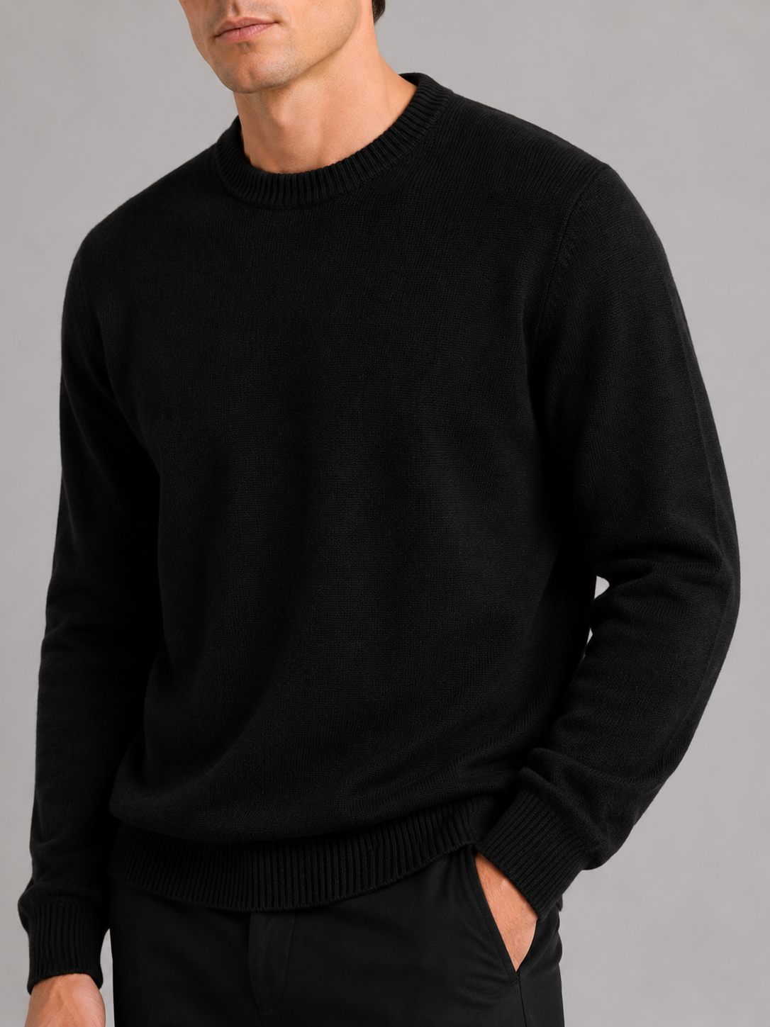 Close up of black knit sweater showing soft textured fabric and classic crew neck detail
