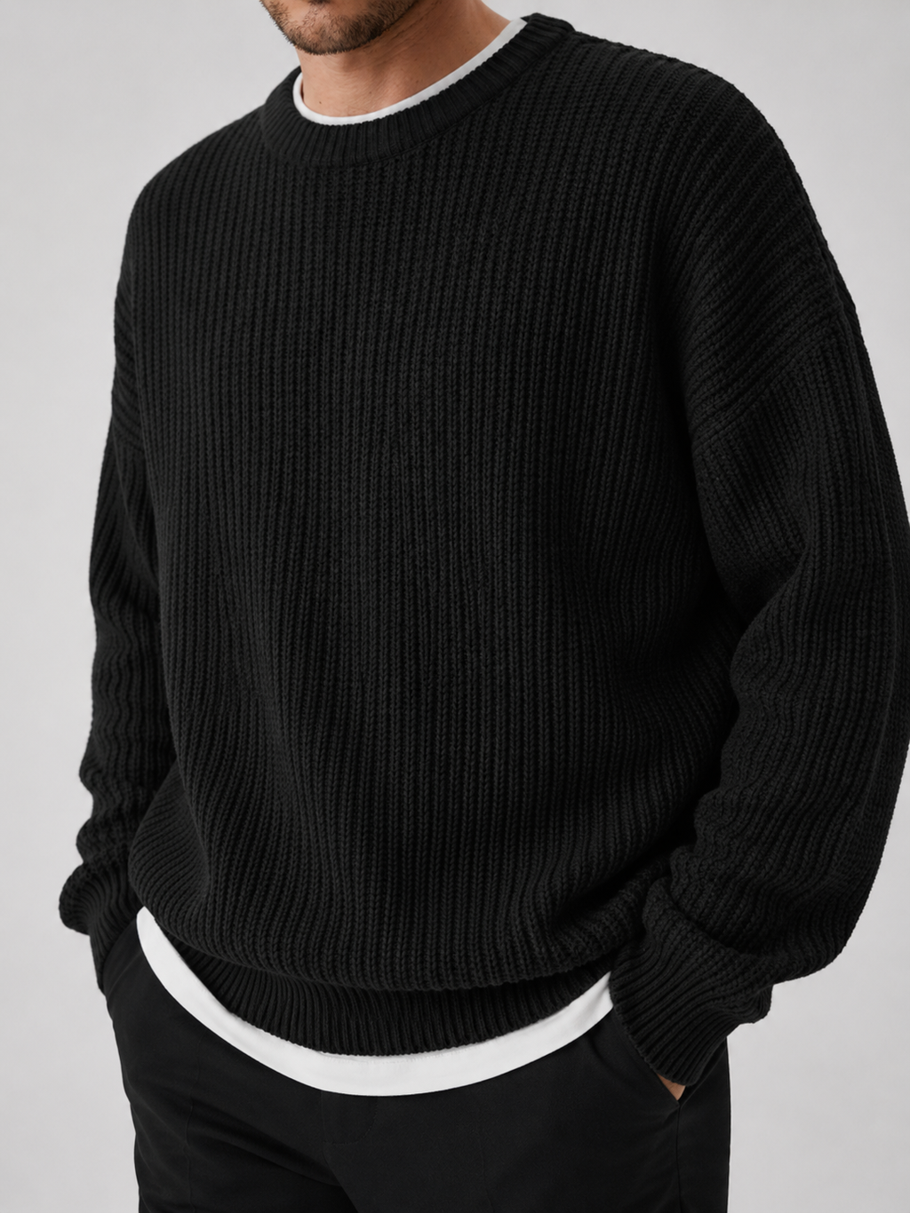 Close up of black crewneck sweater showing soft knit texture and classic ribbed neckline detail
