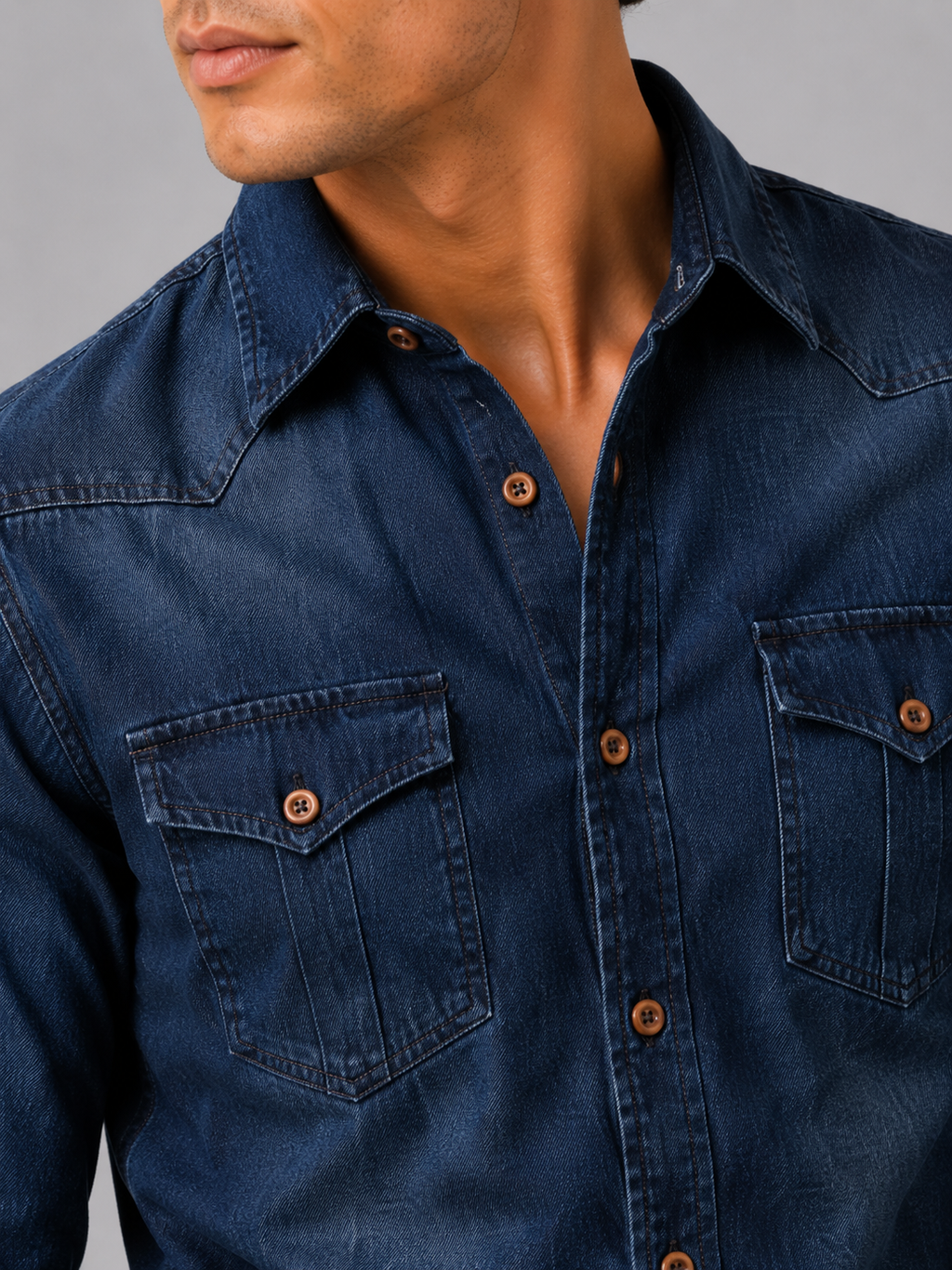 Close up of navy denim shirt showing washed cotton texture and button up detail