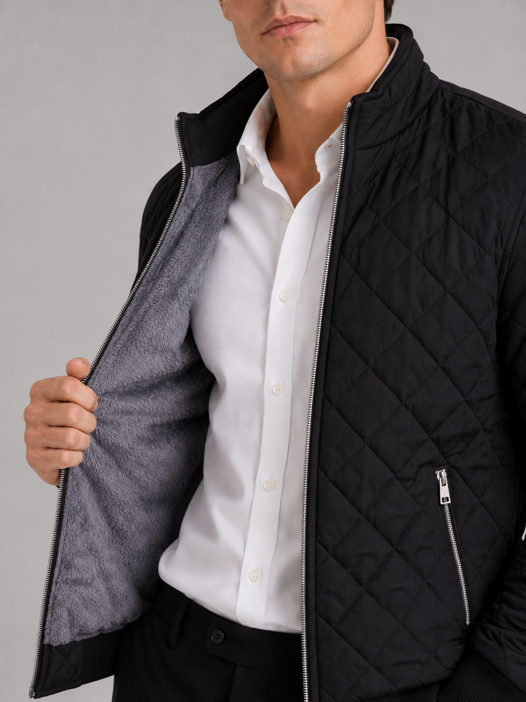 Close up of black diamond pattern bomber jacket showing fleece lining and textured fabric detail