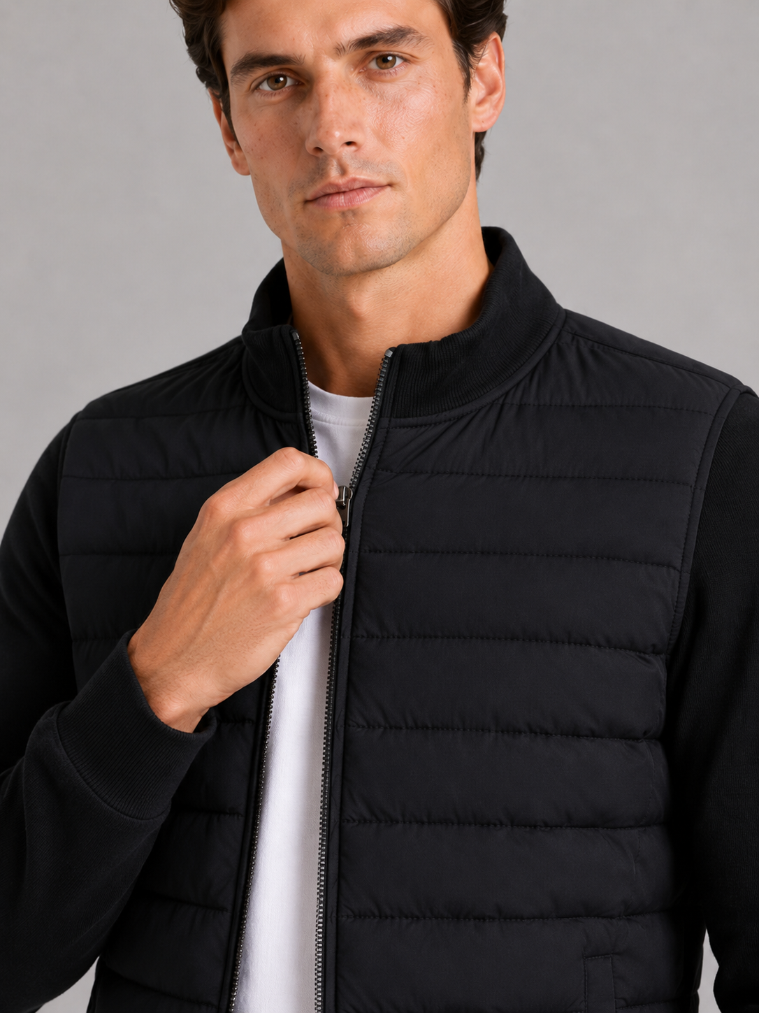 Close up of black down jacket showing smooth padded fabric and stand collar detail