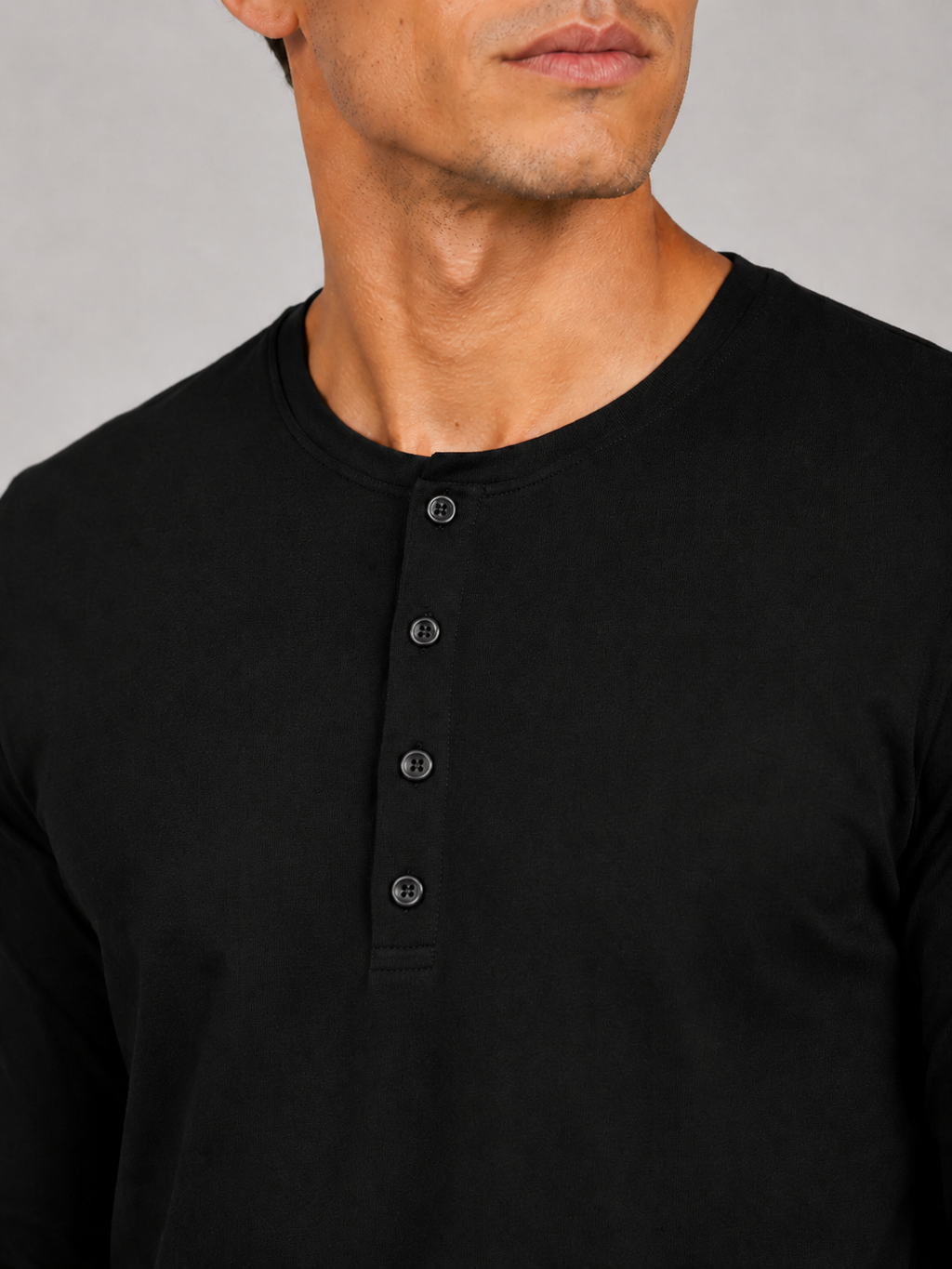 Close up of black henley shirt fabric showing soft smooth breathable texture and button detail
