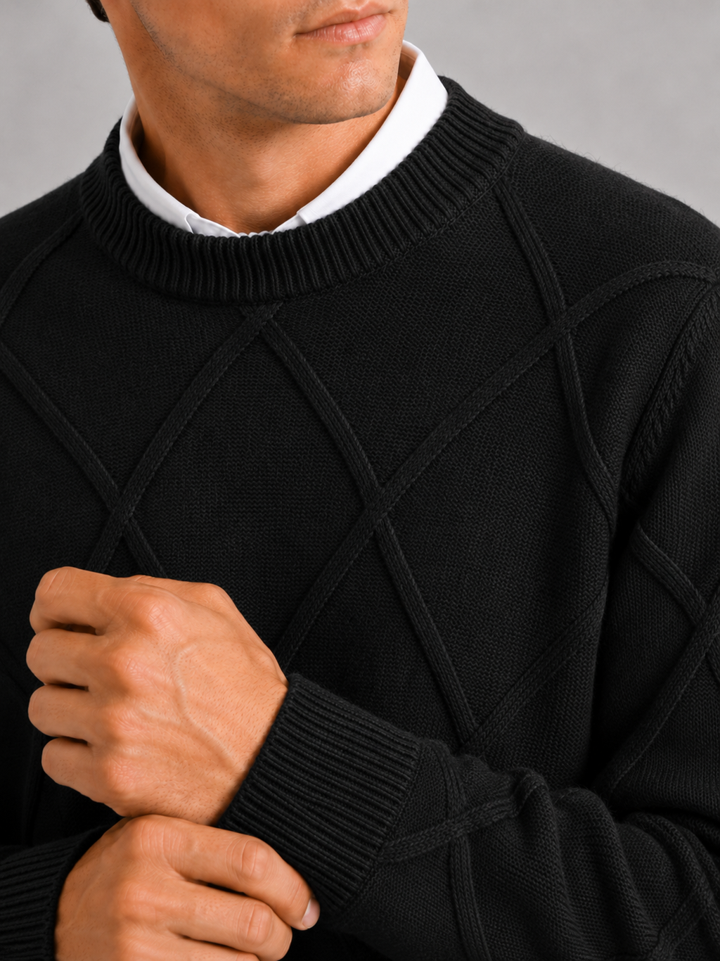 Close up of black cable knit sweater showing soft fleece texture and thick woven detail