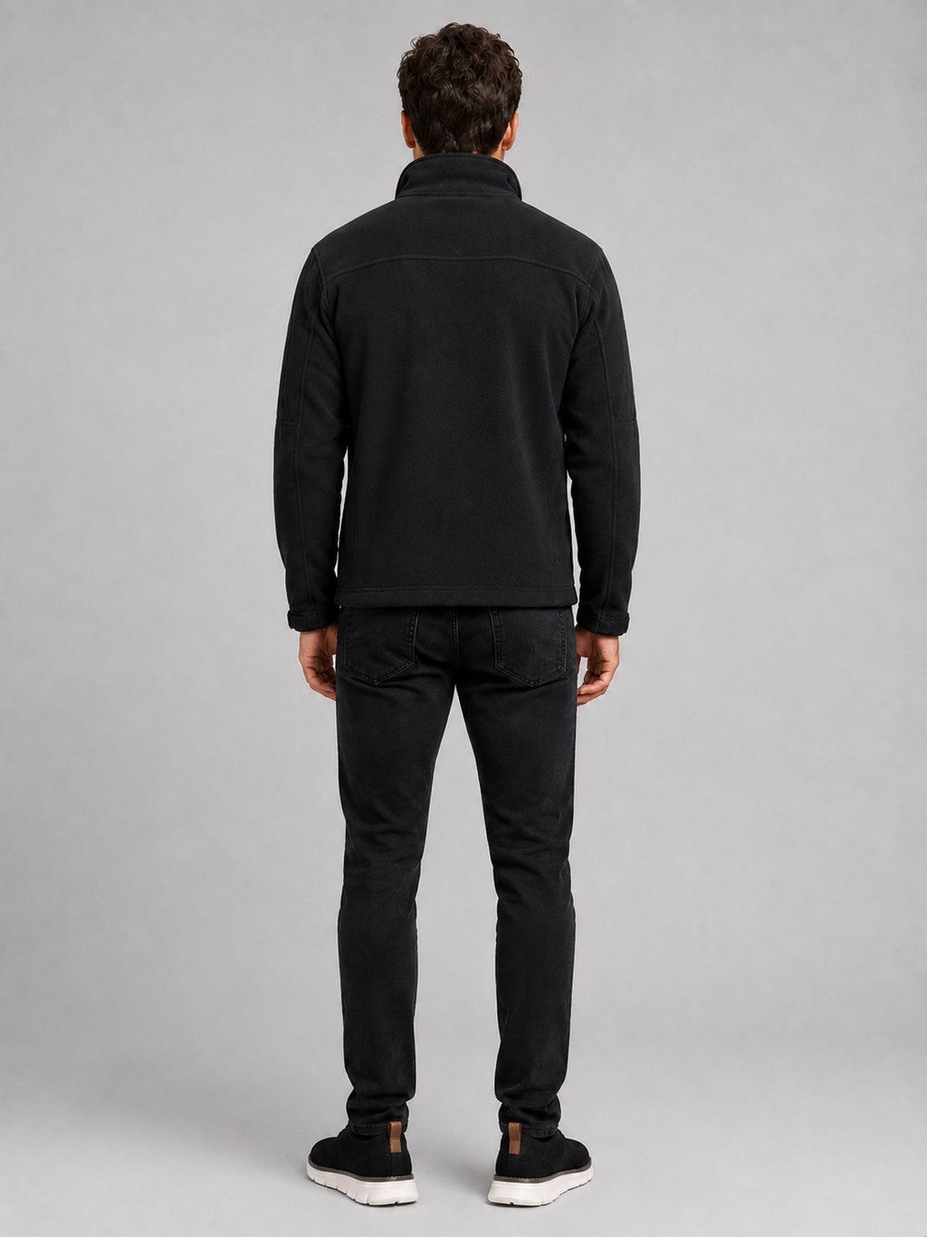 Back view of a man wearing a black fleece jacket showing the warm fleece construction, long sleeves, and comfortable outdoor fit