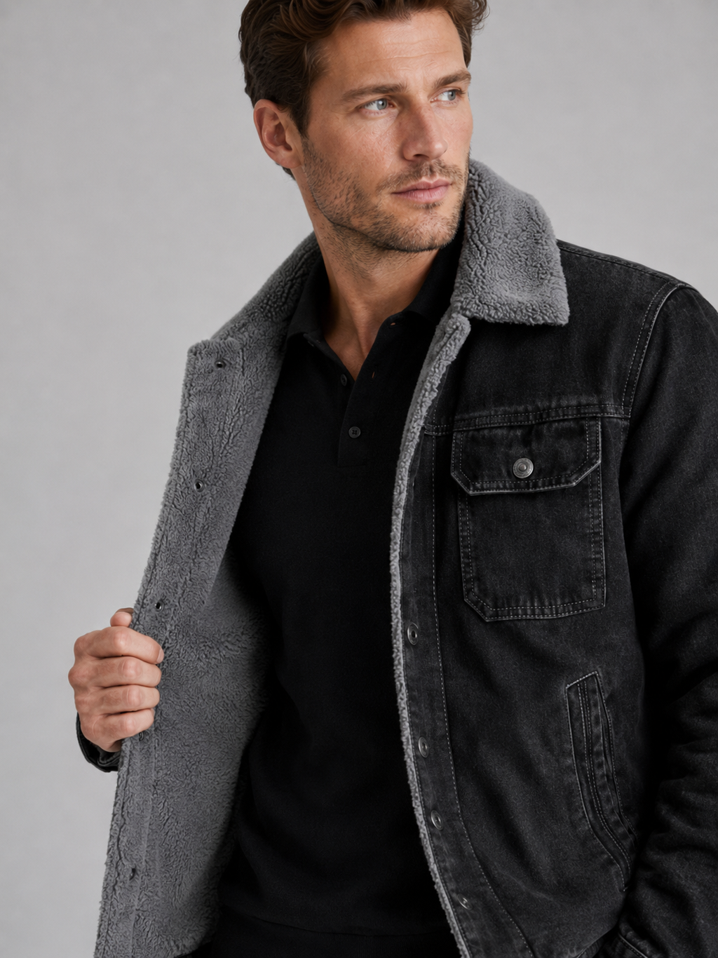 Close up of black denim jacket showing soft fleece lining, durable denim fabric, and insulated stitching detail