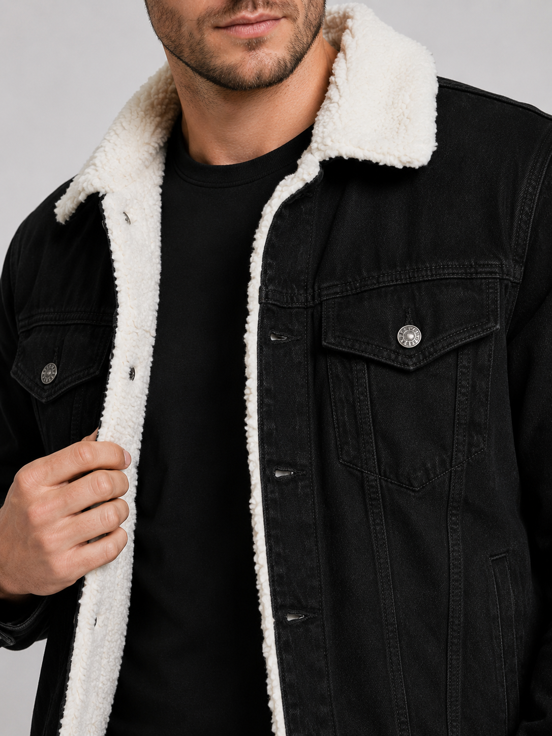 Close up of black denim jacket showing soft fleece lining, durable fabric, and turn down collar detail