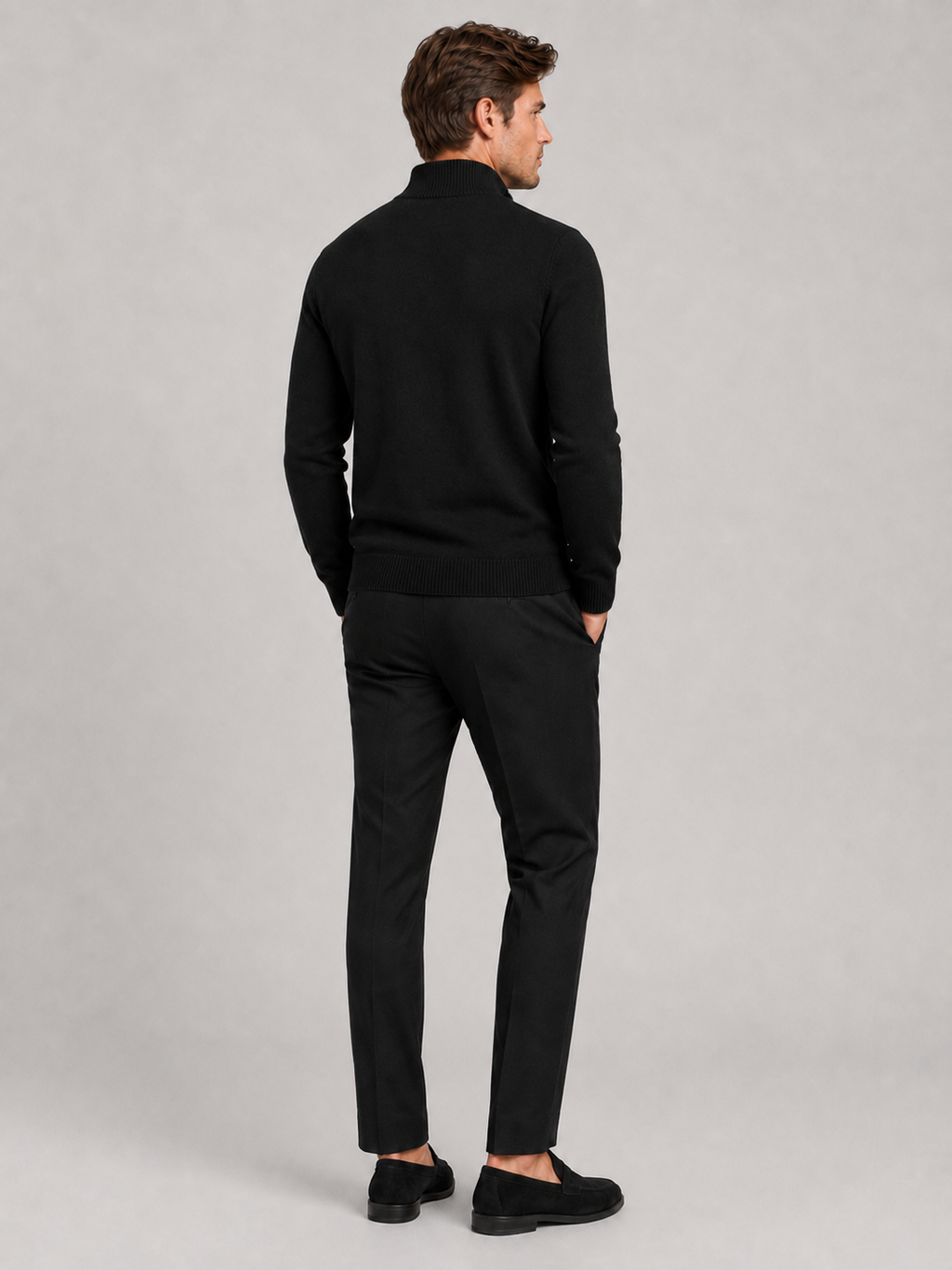 Back view of a man wearing a black full zip knit sweater showing the slim fit, long sleeves, and clean knit construction