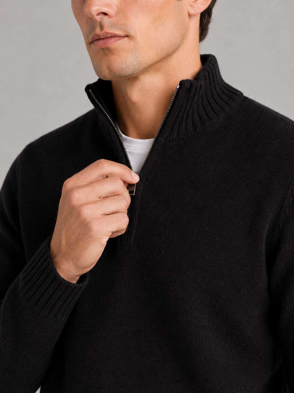 Close up of black half zip sweater showing soft knit texture and refined zipper detail