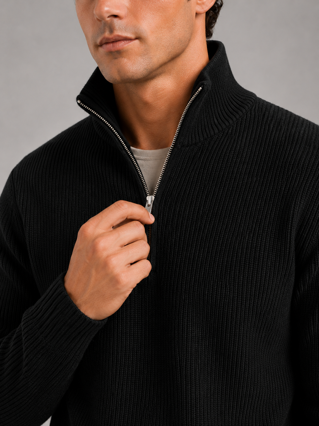 Close up of black half zip sweater showing thick knit texture and refined zipper detail