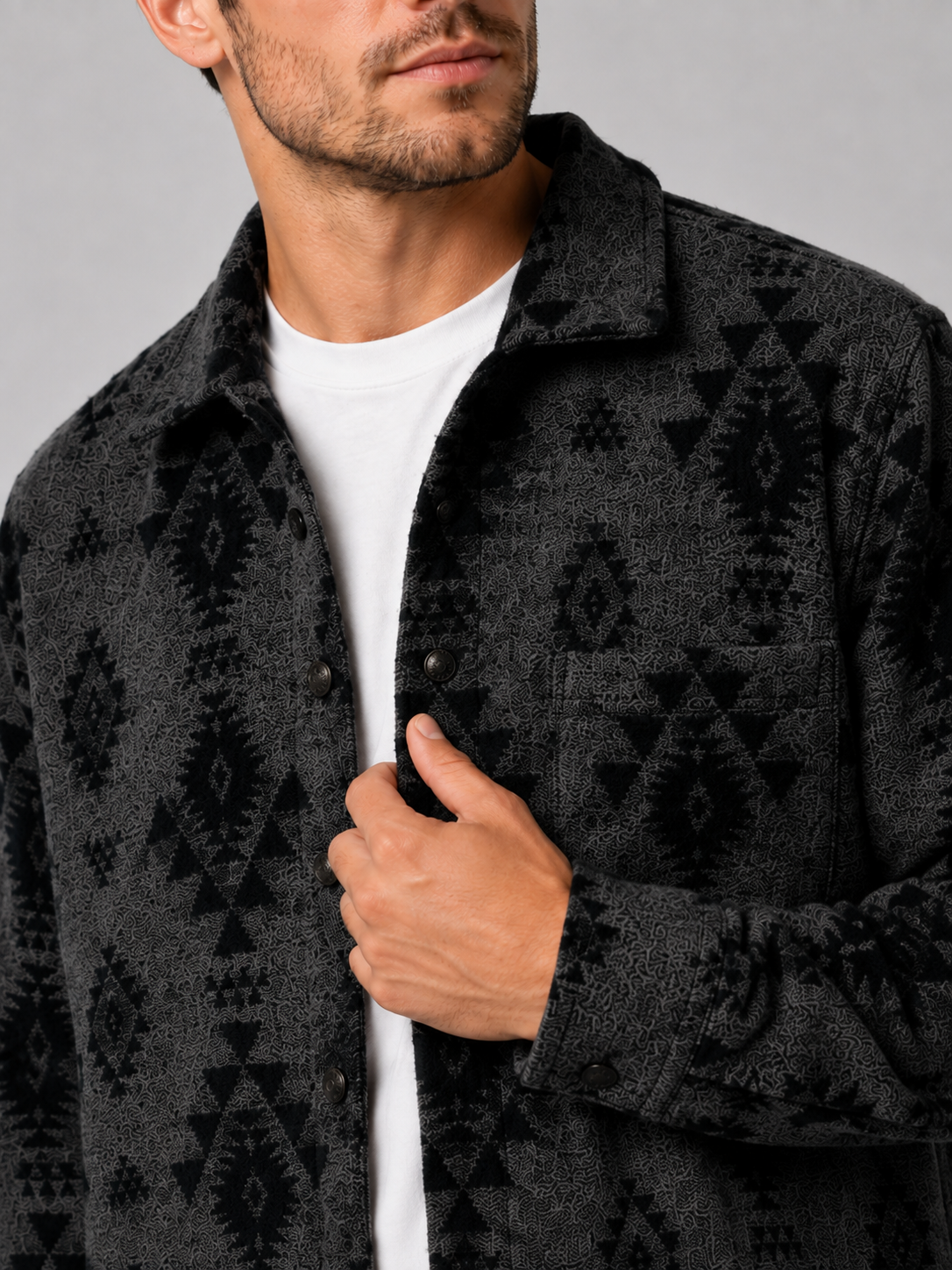 Close-up of a black heavyweight flannel jacket showing the premium brushed fabric, thick wool-blend texture, button closure, collar, chest pockets, and reinforced stitching