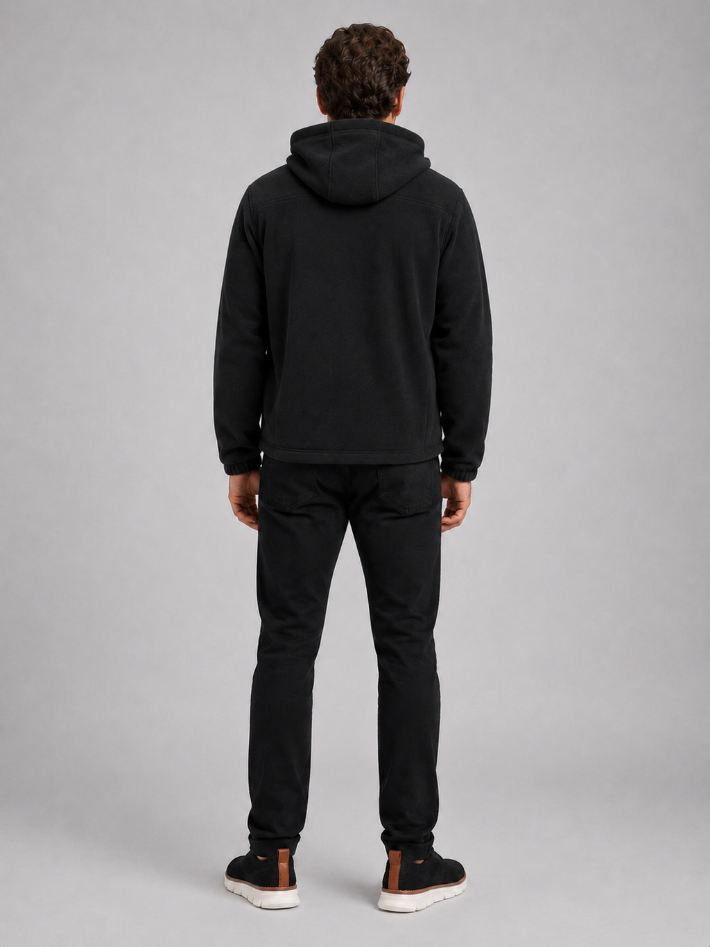 Back view of a man wearing a black hooded fleece jacket showing the attached hood, thick fleece construction, long sleeves, and comfortable outdoor fit