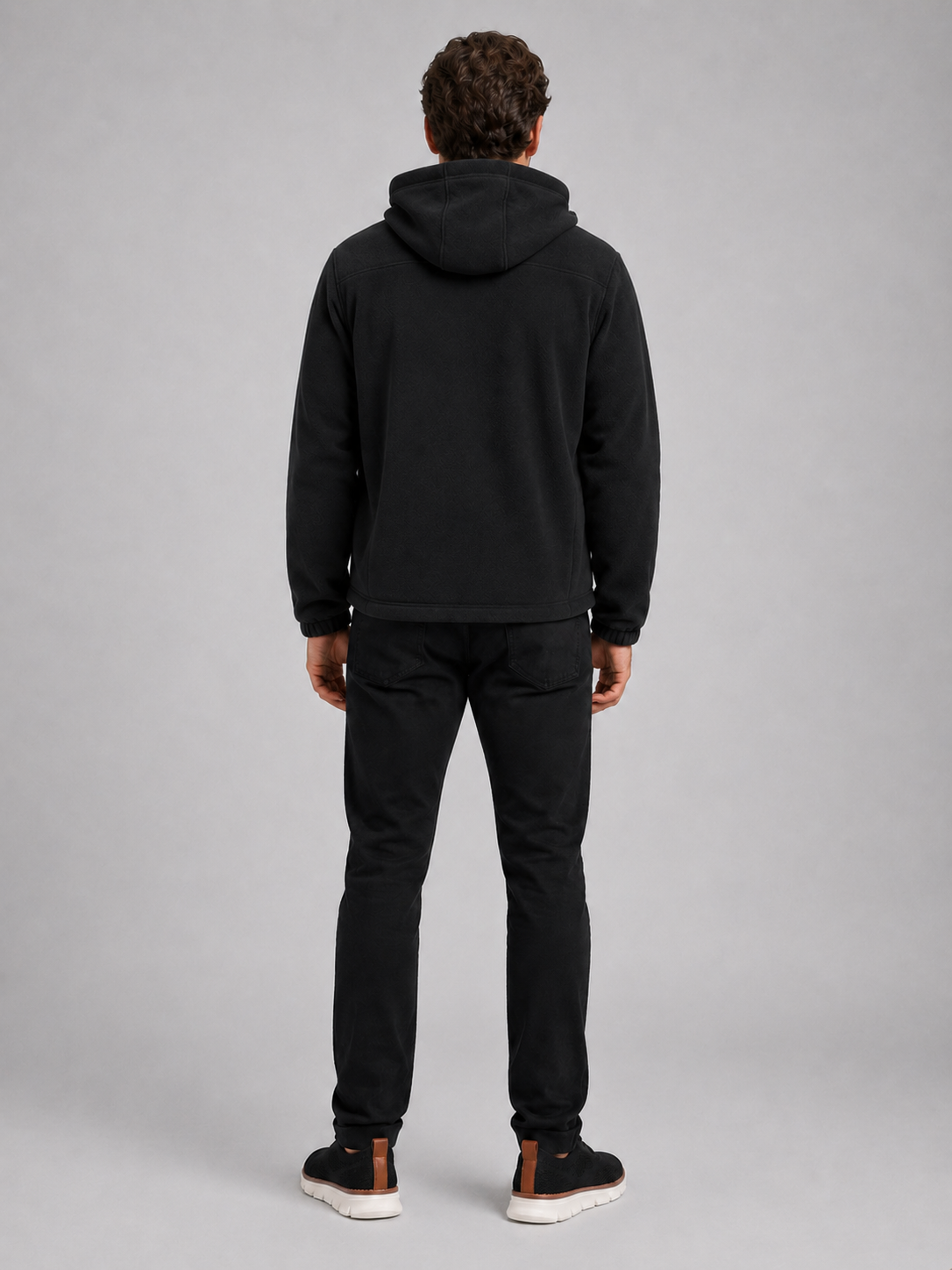 Back view of a man wearing a black hooded fleece jacket showing the attached hood, thick fleece construction, long sleeves, and comfortable outdoor fit