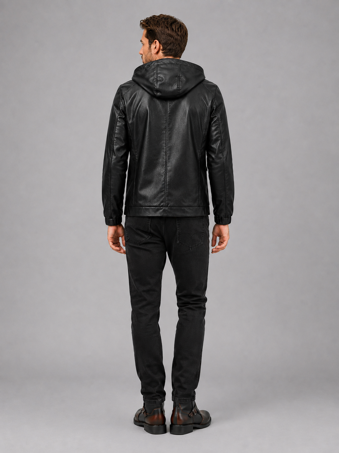 Back view of a man wearing a black hooded leather jacket showing the attached hood, relaxed fit, long sleeves, and clean back design