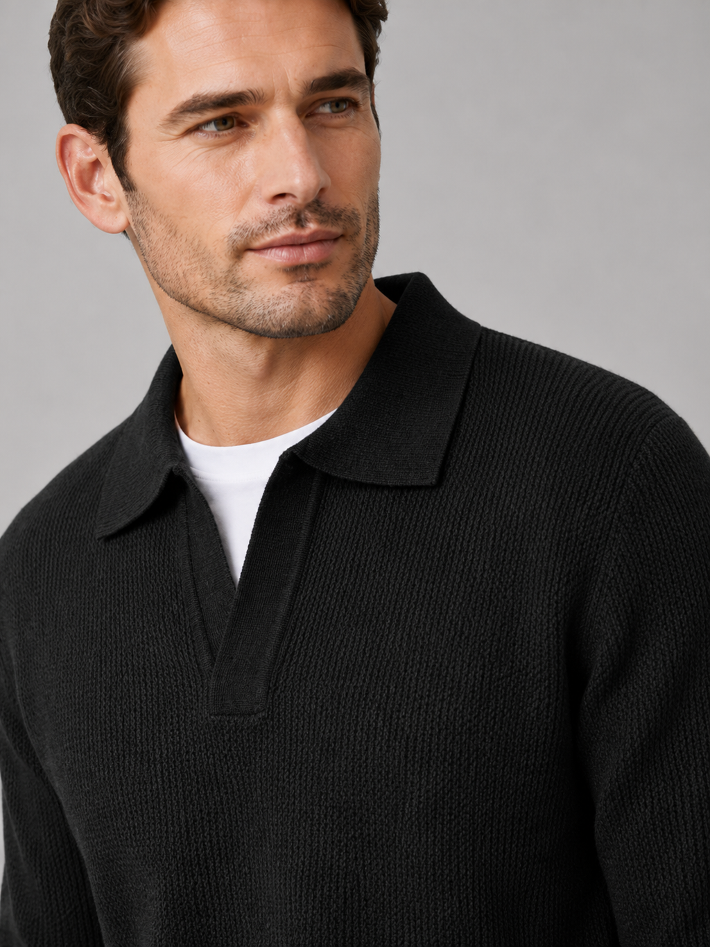 Close-up of a black Johnny collar sweater showing the thick knit texture, open polo collar, cuffs, and stitching