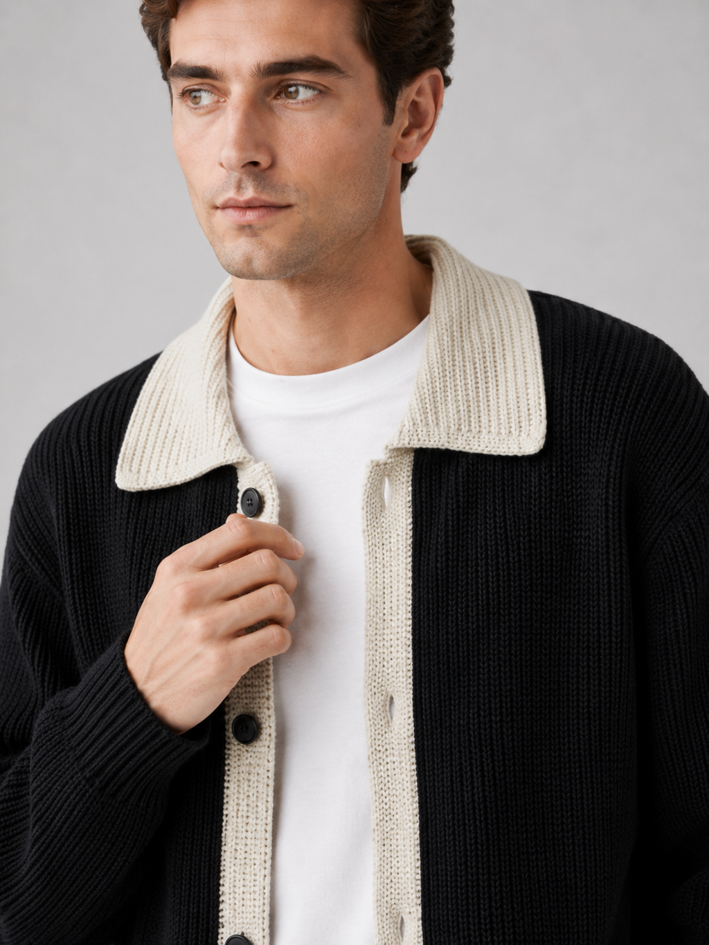 Close up of black cardigan sweater showing contrast collar detail and soft knit texture