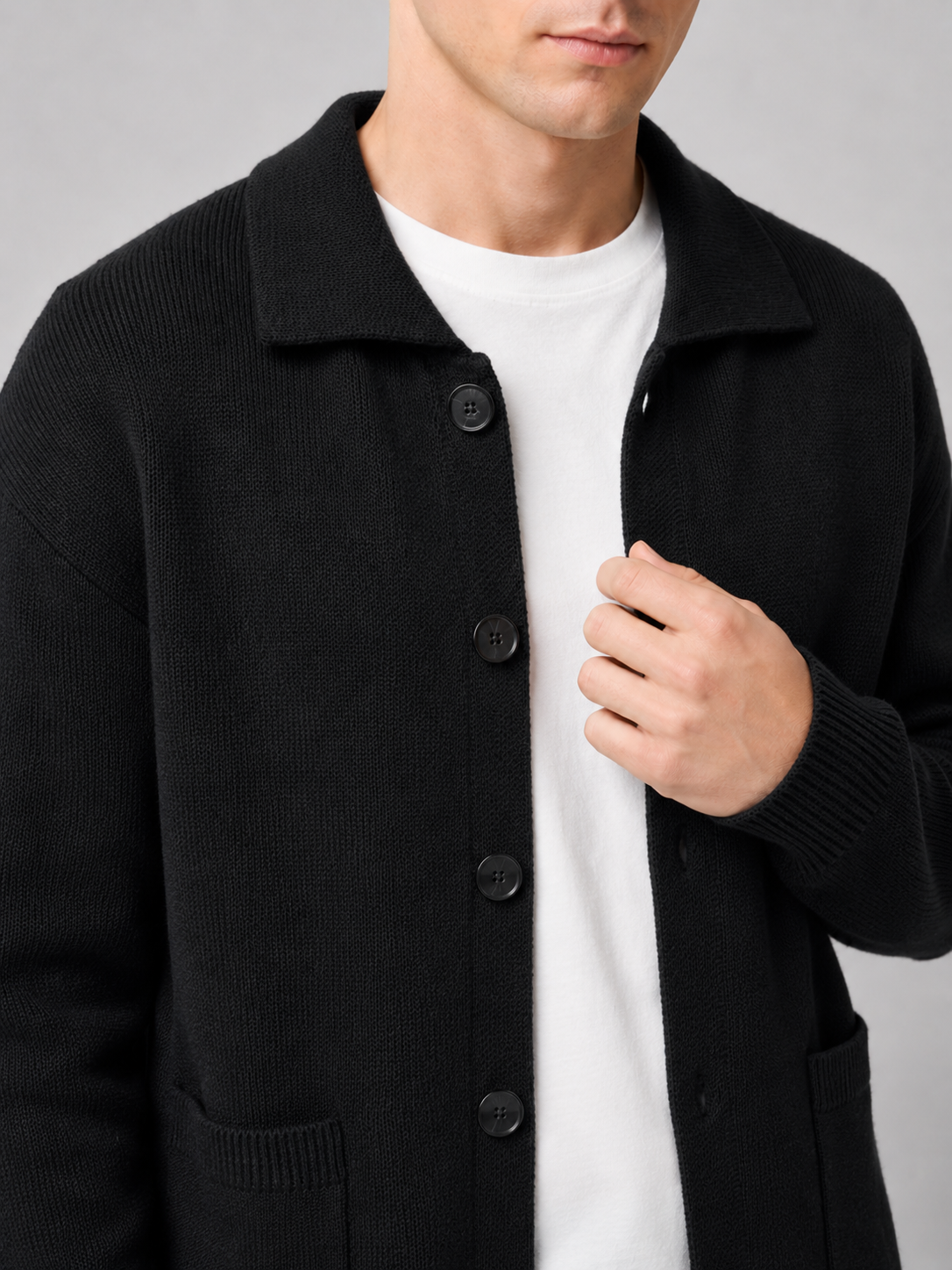 Close up of black cardigan sweater showing soft knit texture and refined lapel button detail