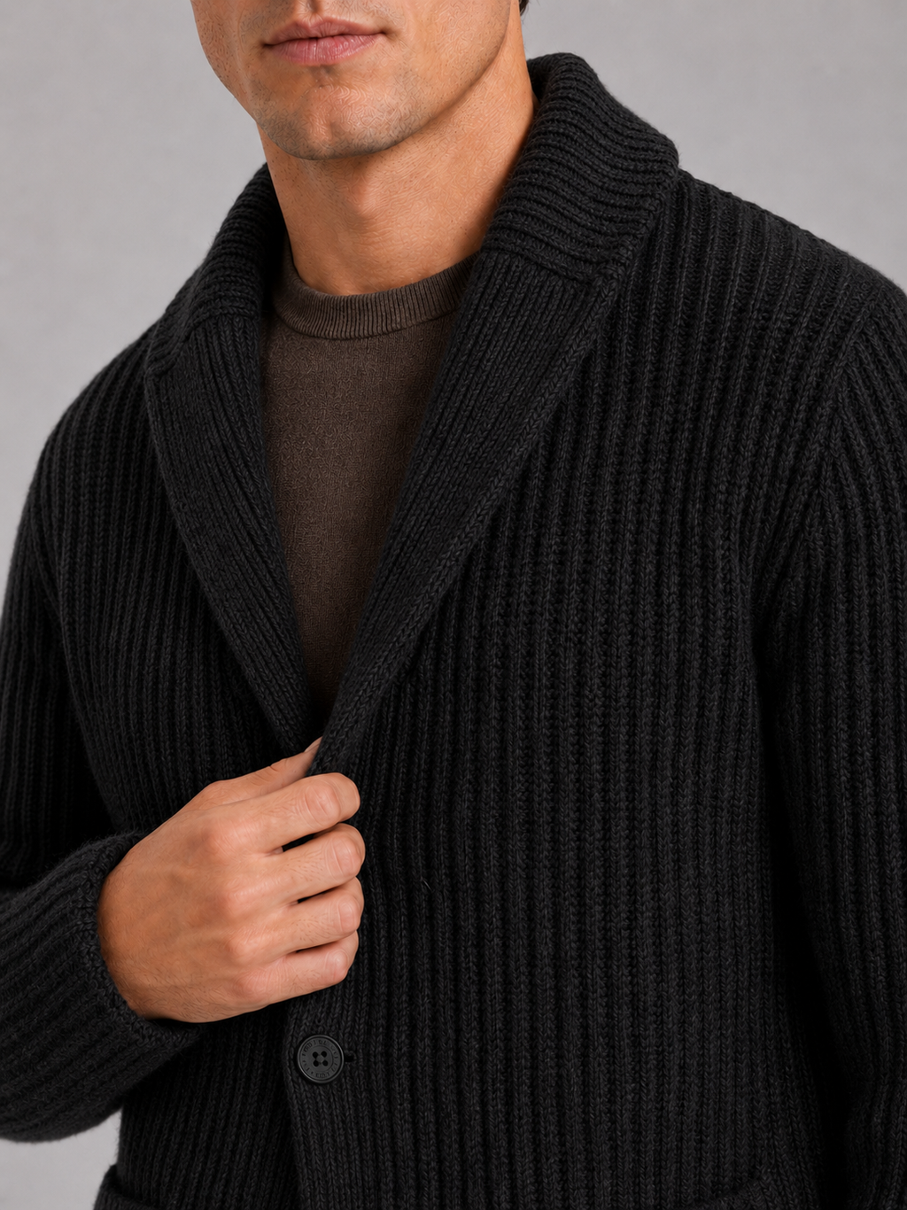 Close up of black knit cardigan showing soft warm texture and refined lapel button detail