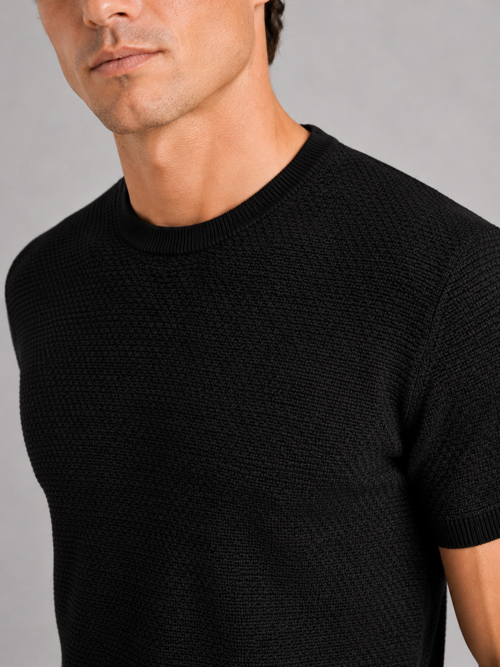 Close up of black merino wool knit t shirt showing soft breathable texture and crew neck detail