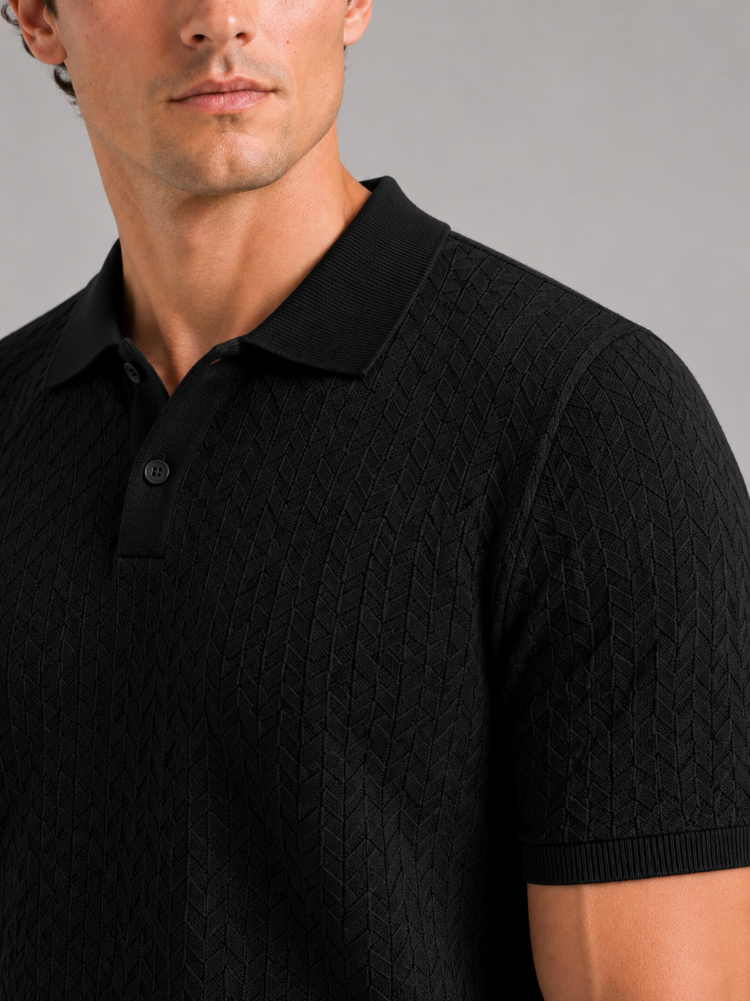 Close up of black knit polo shirt showing soft breathable fabric and refined collar detail