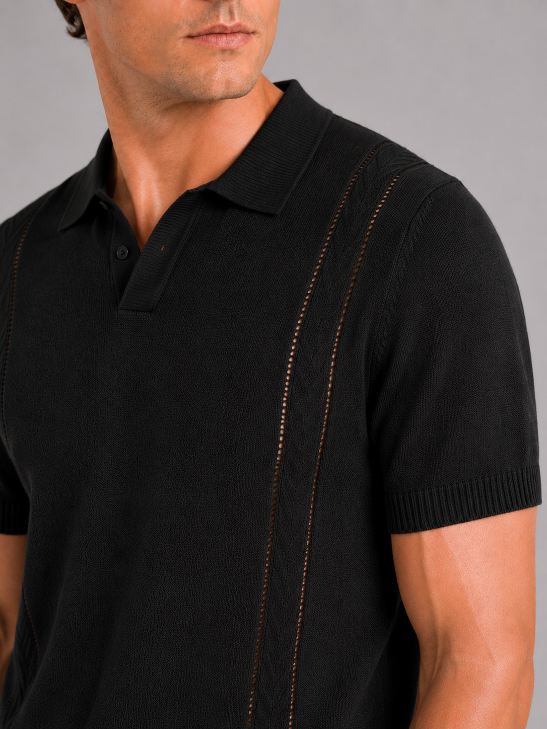 Close up of black knit polo shirt showing soft breathable fabric and refined collar detail