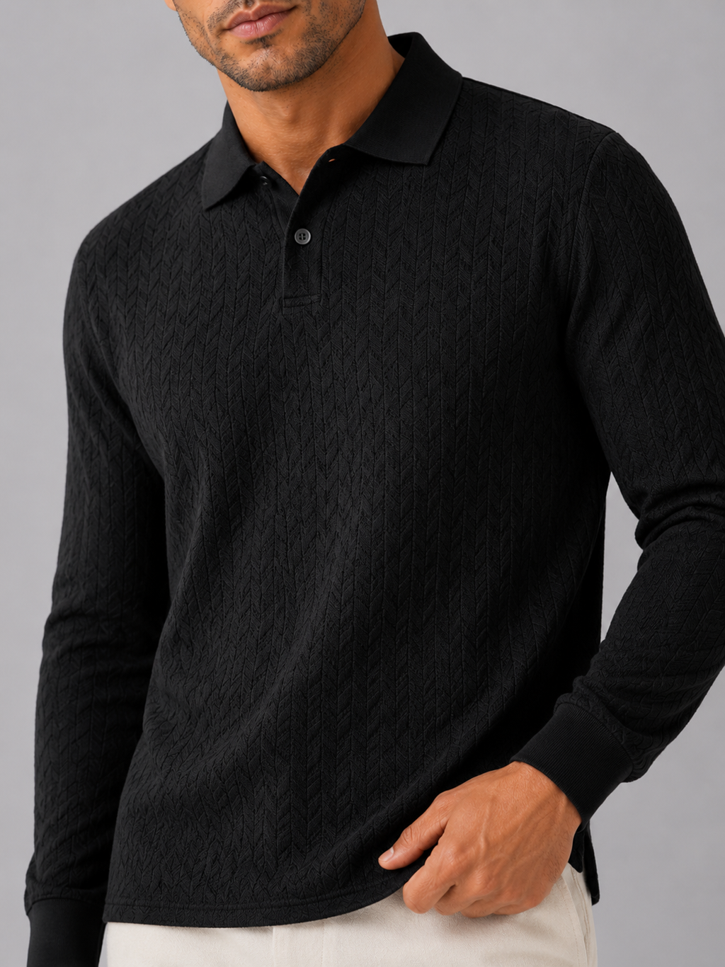 Close up of black knit polo shirt showing soft textured fabric and refined collar detail