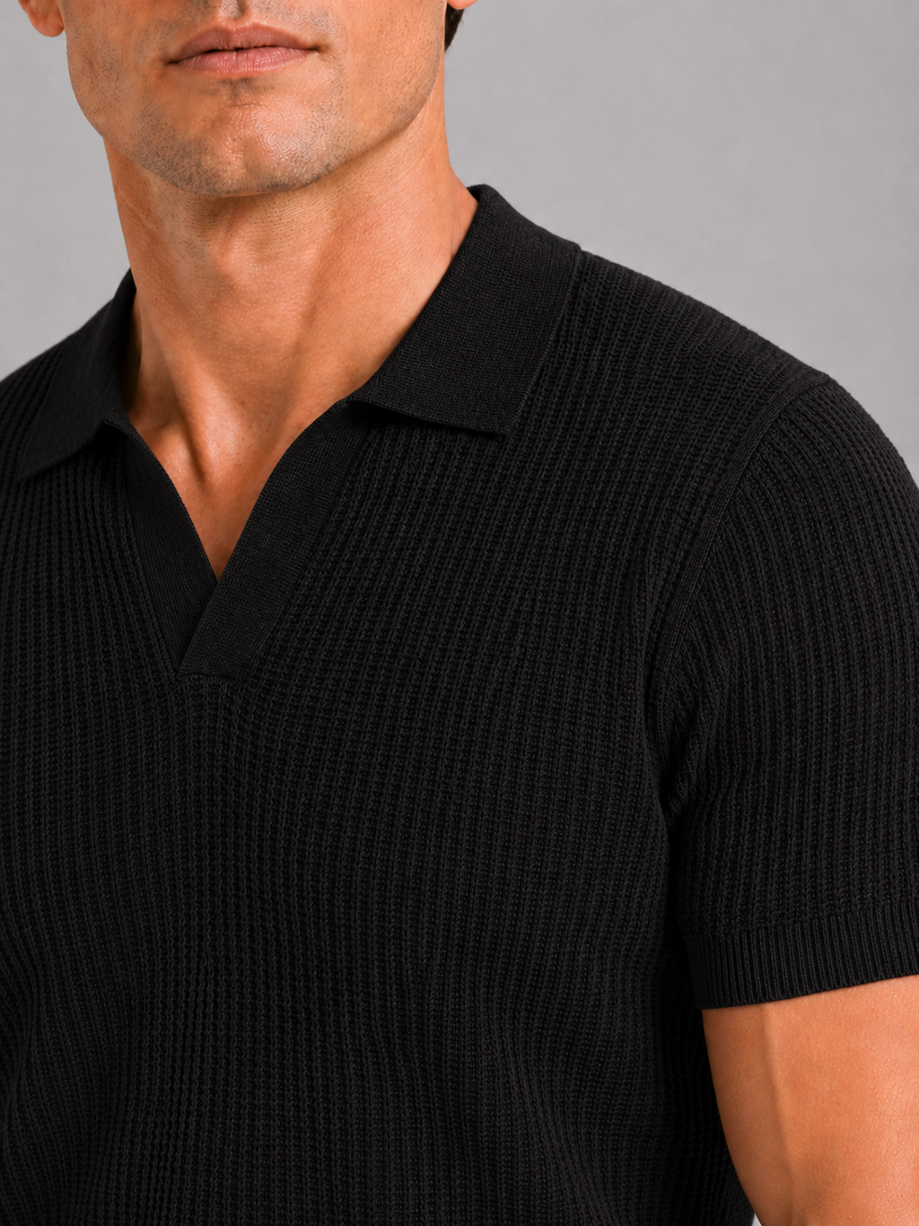 Close up of black knit polo showing soft breathable fabric and refined collar detail