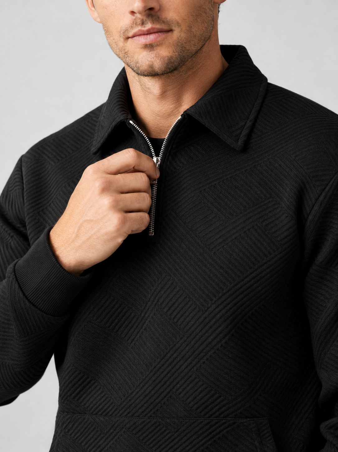 Close up of black quarter zip sweater showing soft knit texture and refined zipper collar detail