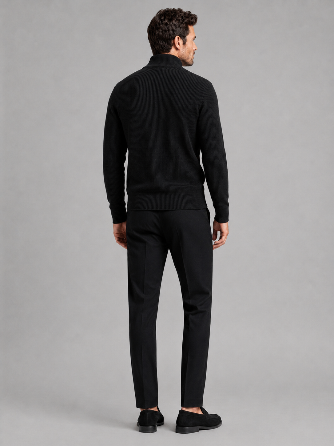 Back view of a man wearing a black ribbed knit cardigan showing the slim fit, long sleeves, and textured knit construction