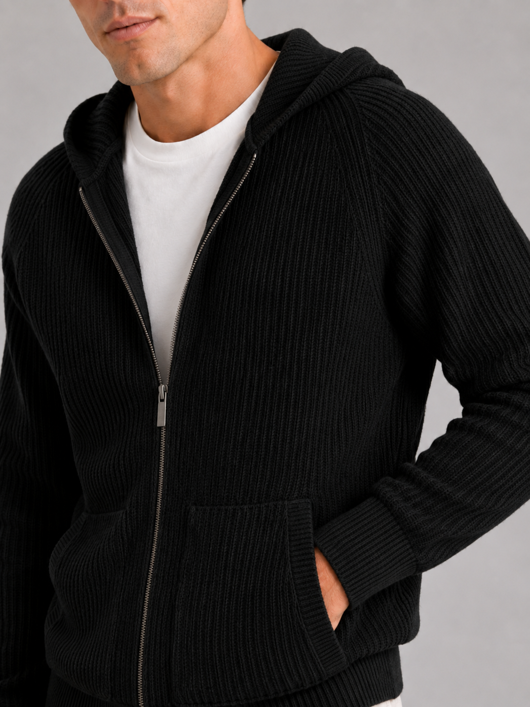 Close up of black merino wool cardigan showing thick knit texture and zipper detail