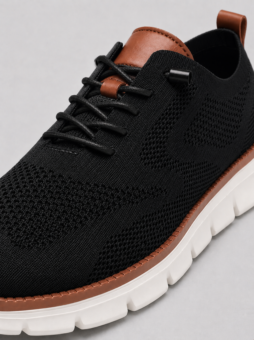Close up of black mesh sneakers showing breathable knit upper and cushioned sole detail