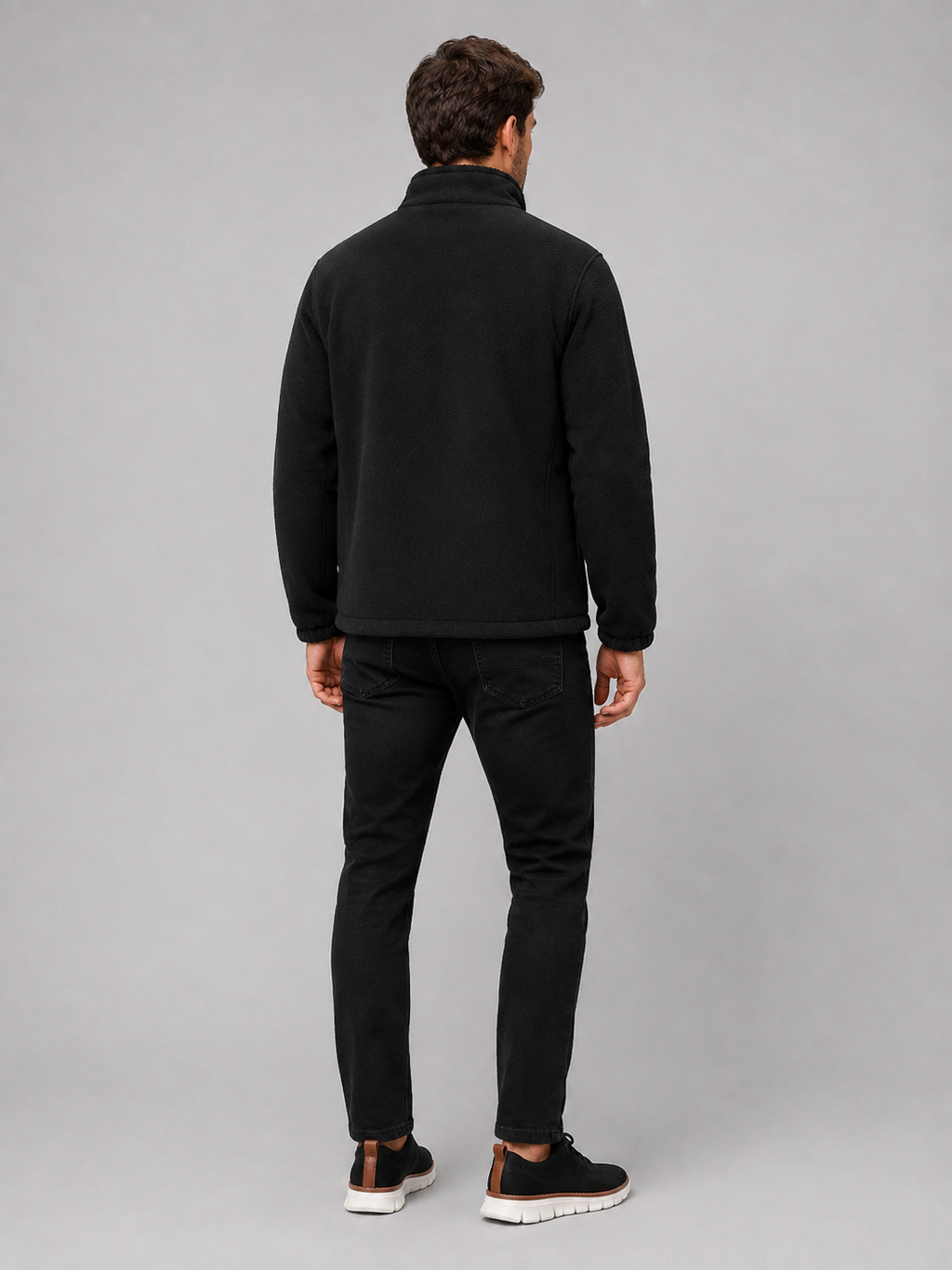 Back view of a man wearing a black polar fleece jacket showing the stand collar, long sleeves, thick fleece construction, and comfortable outdoor fit