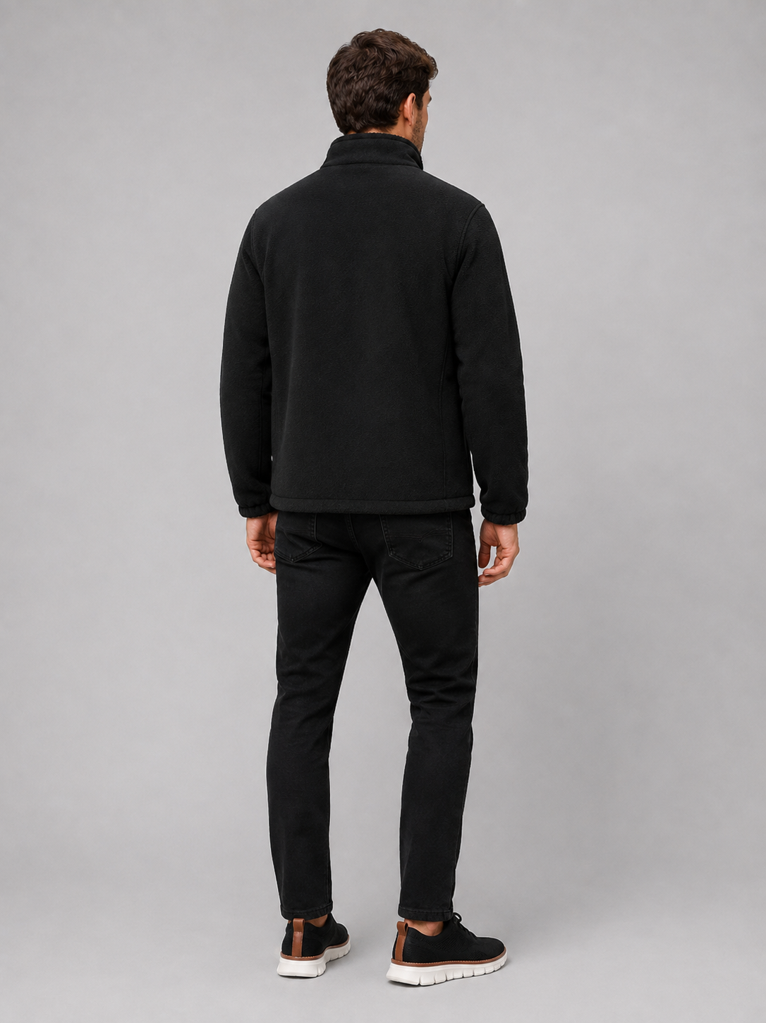 Back view of a man wearing a black polar fleece jacket showing the stand collar, long sleeves, thick fleece construction, and comfortable outdoor fit