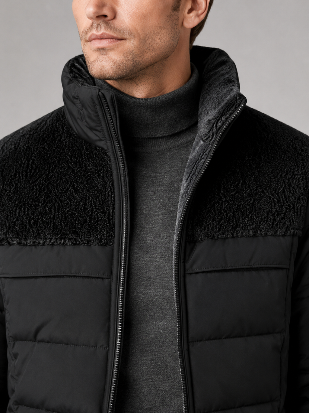 Close up of black puffer jacket showing plush lining, insulated quilting, and stand collar detail