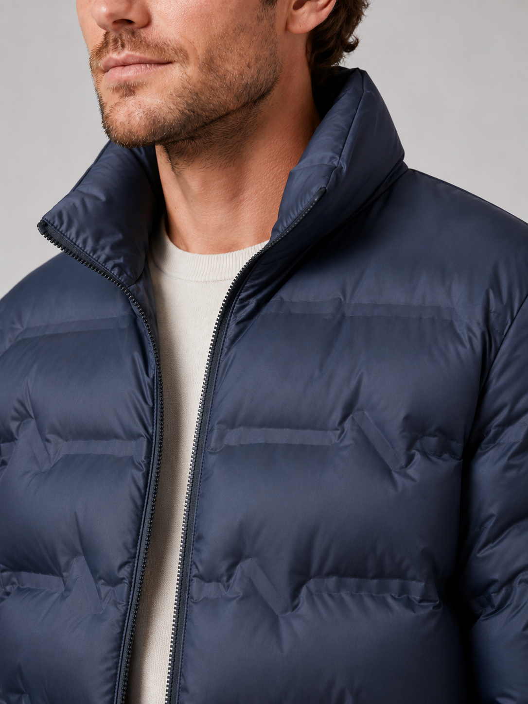 Close up of blue white duck down jacket showing premium quilted insulation, stand collar, and weather resistant fabric detail