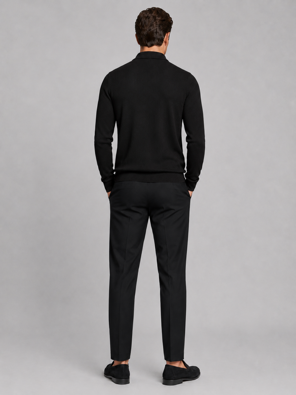 Back view of a man wearing a black quarter zip polo showing the long sleeves, structured collar, and comfortable fall fit