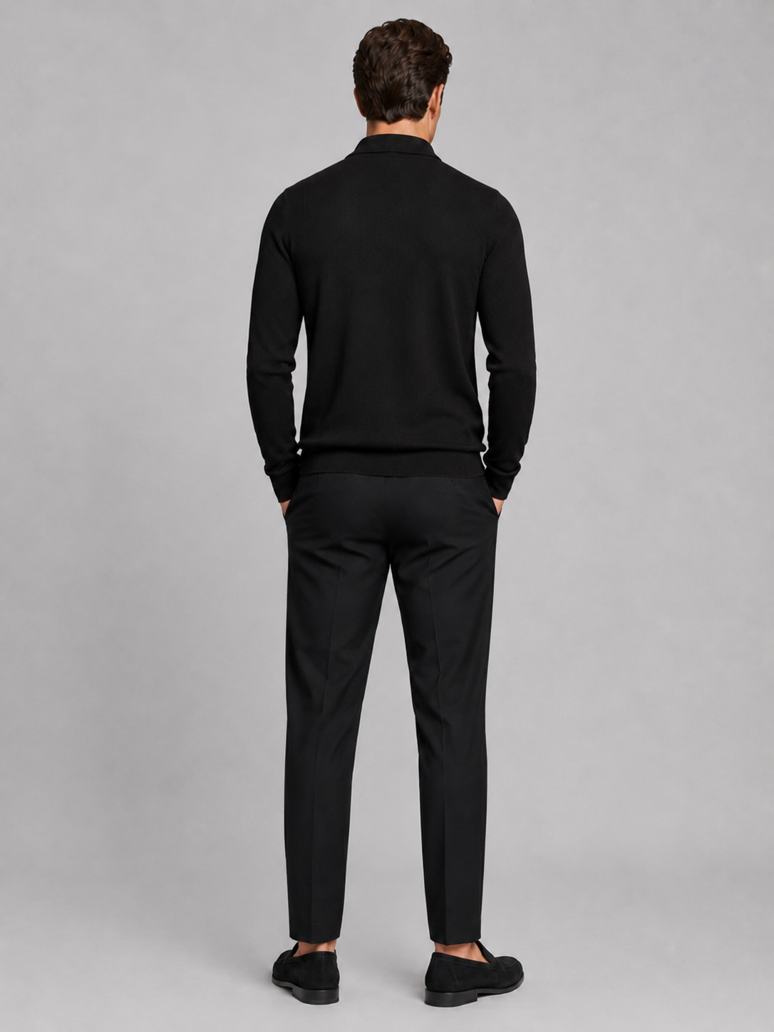 Back view of a man wearing a black quarter zip polo showing the long sleeves, structured collar, and comfortable fall fit