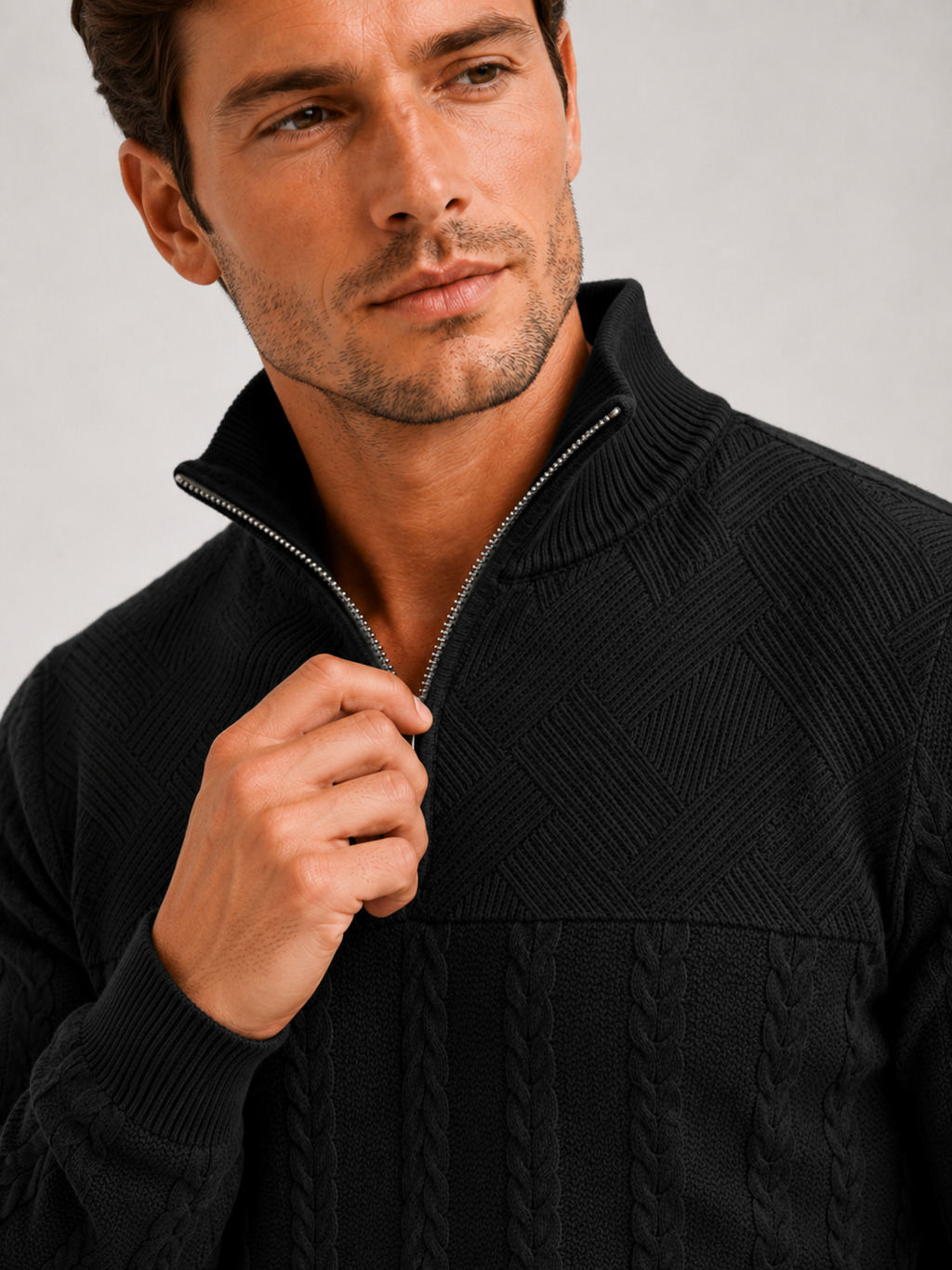 Close up of black jacquard sweater showing textured knit pattern, quarter zip, and warm fabric detail
