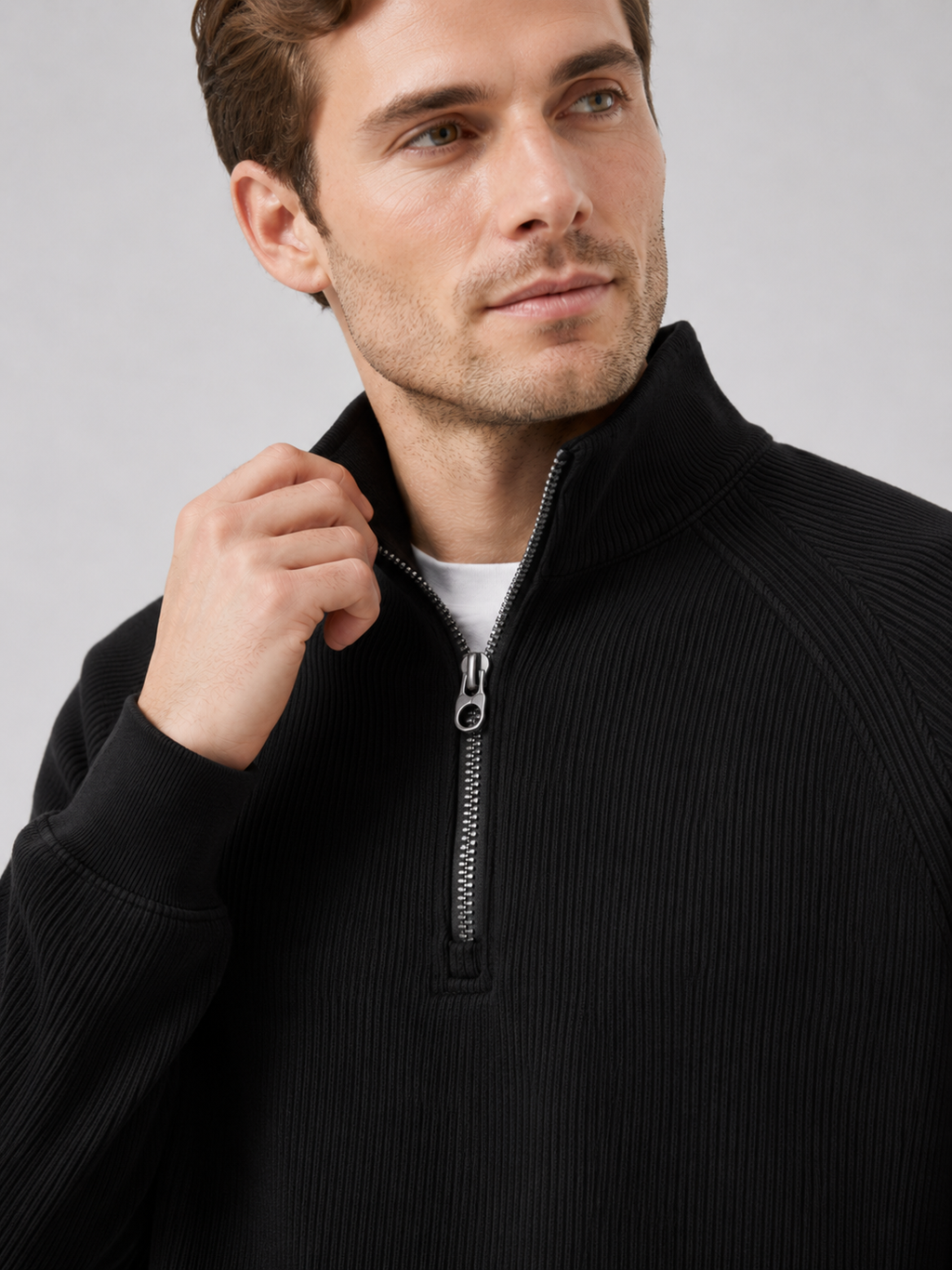 Close up of black quarter zip sweater showing soft knit texture and stand collar zipper detail