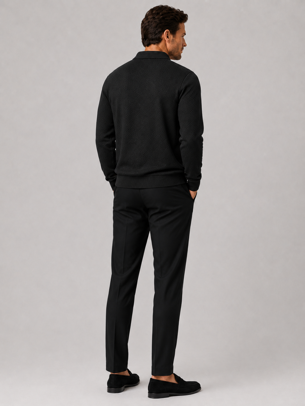 Back view of a man wearing a black quarter zip knit polo sweater showing the lightweight fabric and regular fit