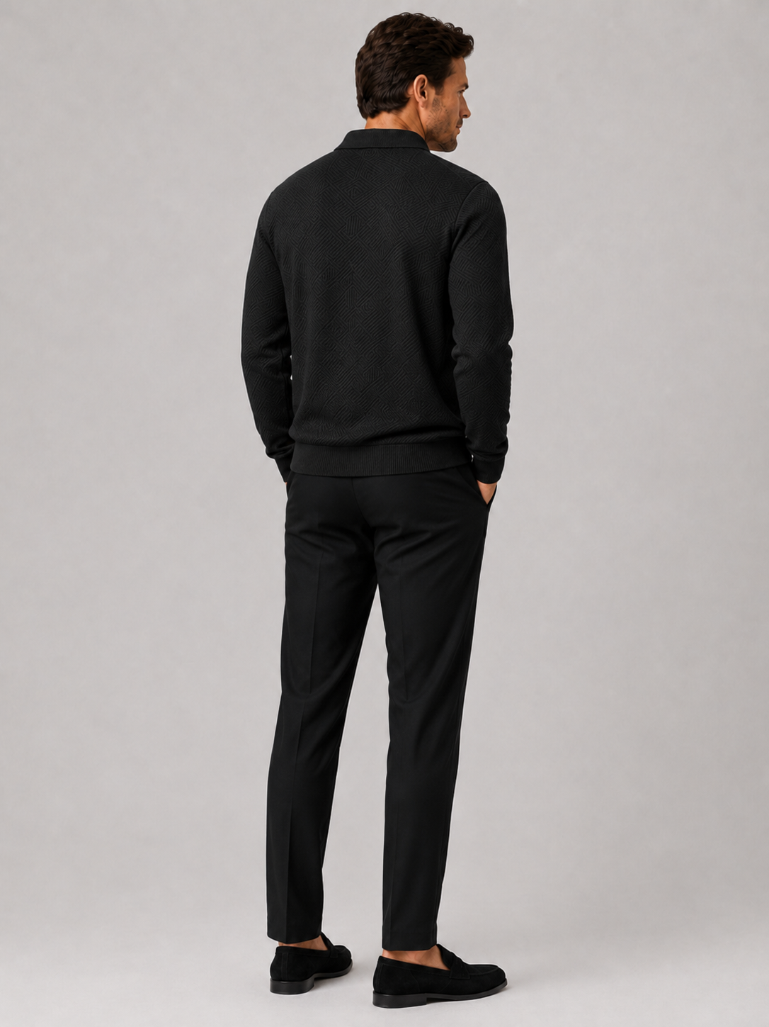 Back view of a man wearing a black quarter zip knit polo sweater showing the lightweight fabric and regular fit