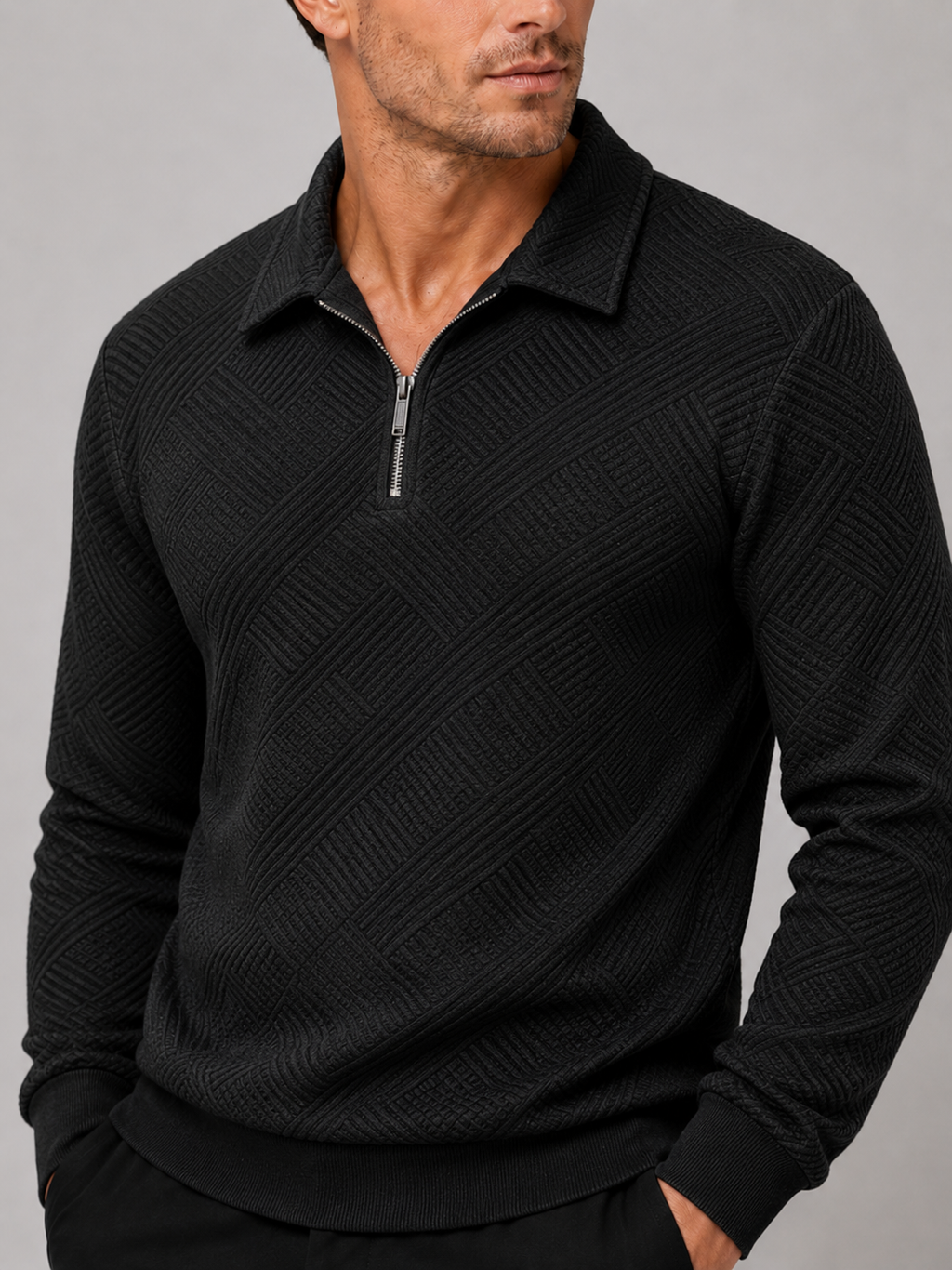 Close-up of a black quarter zip polo sweater showing the fine knit texture, polo collar, zipper, cuffs, and stitching