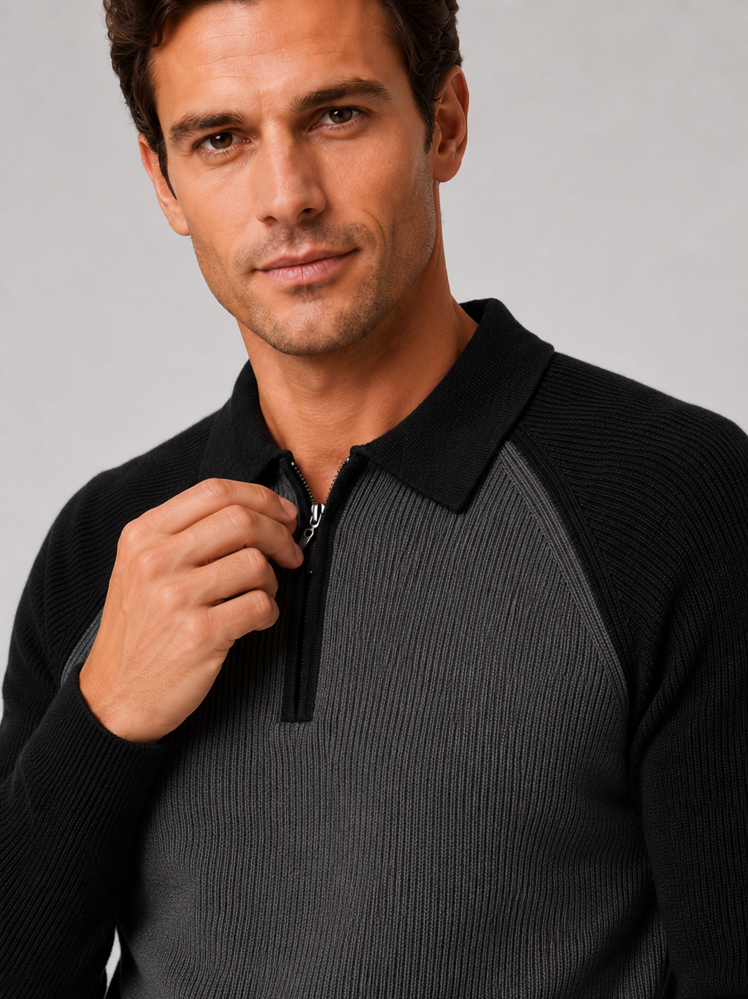 Close-up of a black quarter zip polo sweater showing the knit texture, zipper, collar, cuffs, and stitching