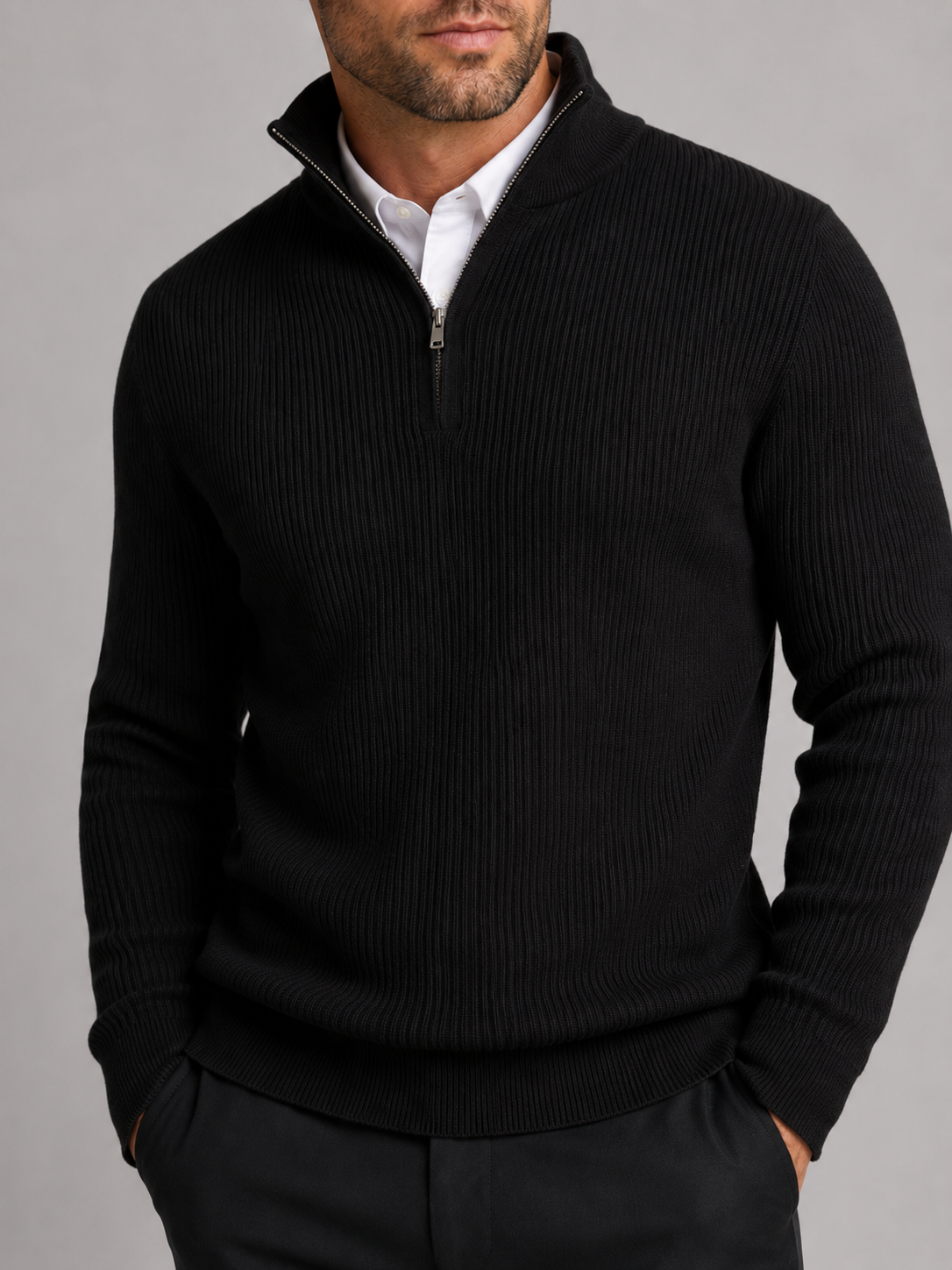 Close-up of a black quarter zip sweater showing the warm knit texture, mock neck, zipper, cuffs, and stitching