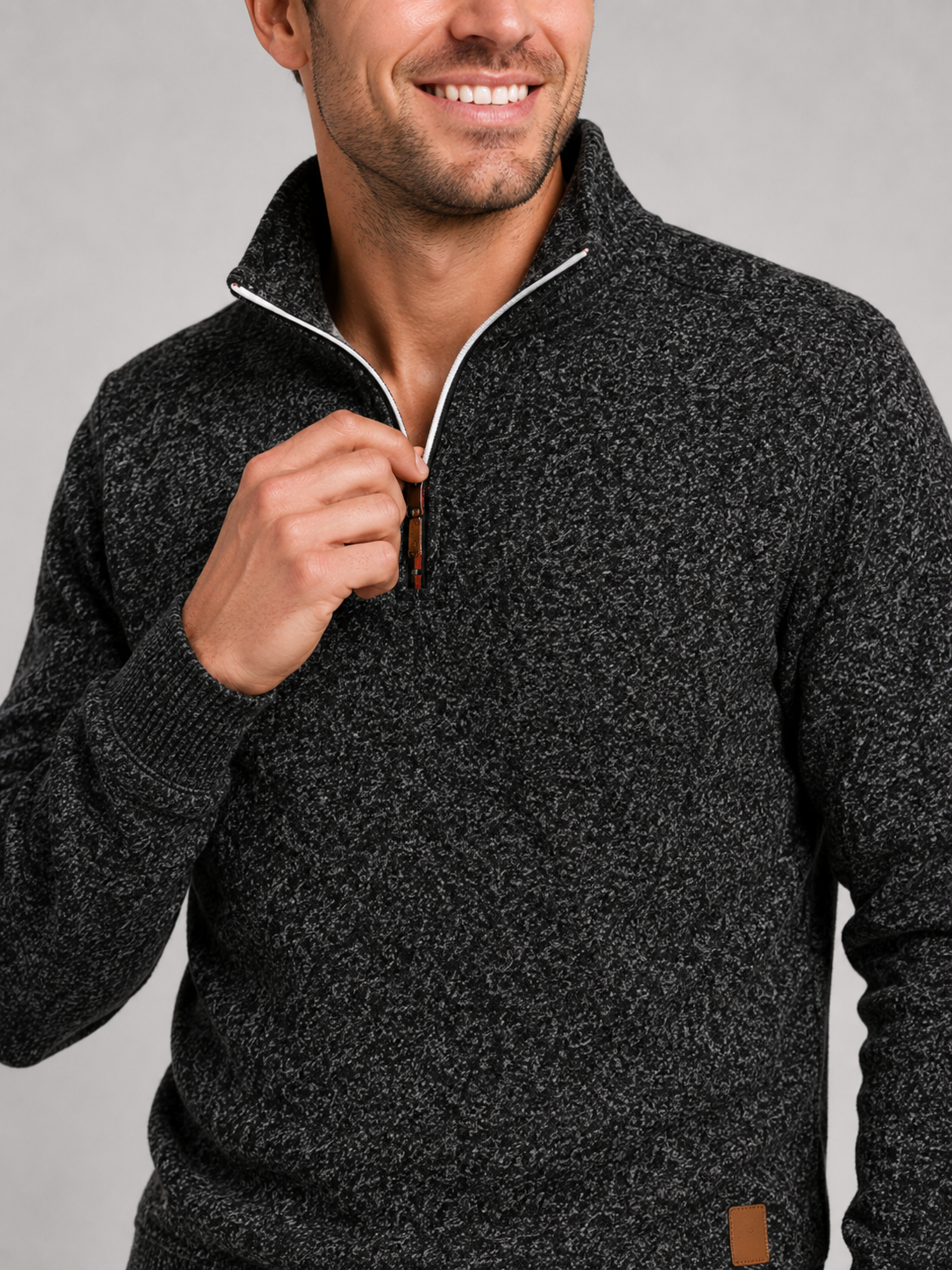 Close up of black quarter zip sweater showing soft knit texture and stand collar zipper detail